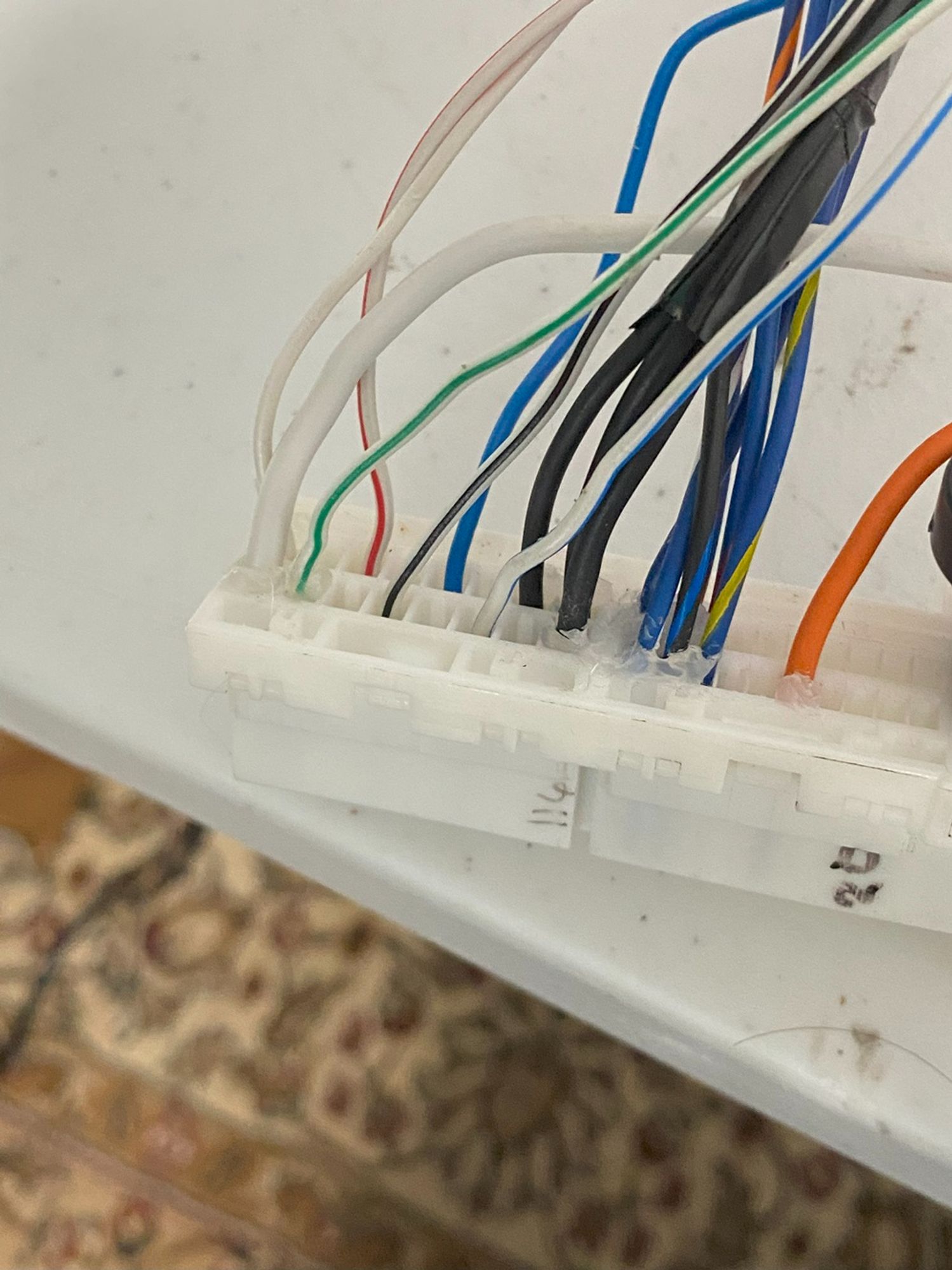 Picture of a wiring harness connector with the six wires from the previous image plugged into it. Other wires are also plugged into the same connector.