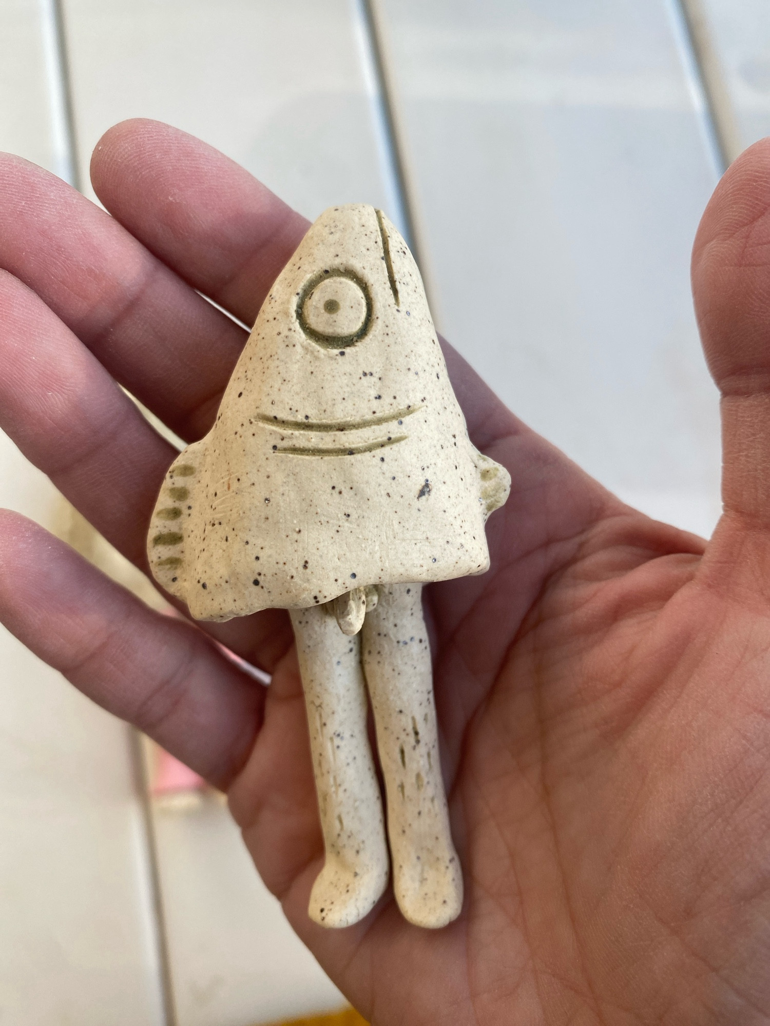 a ceramic little guy. a reverse mermaid with a tiny penis.