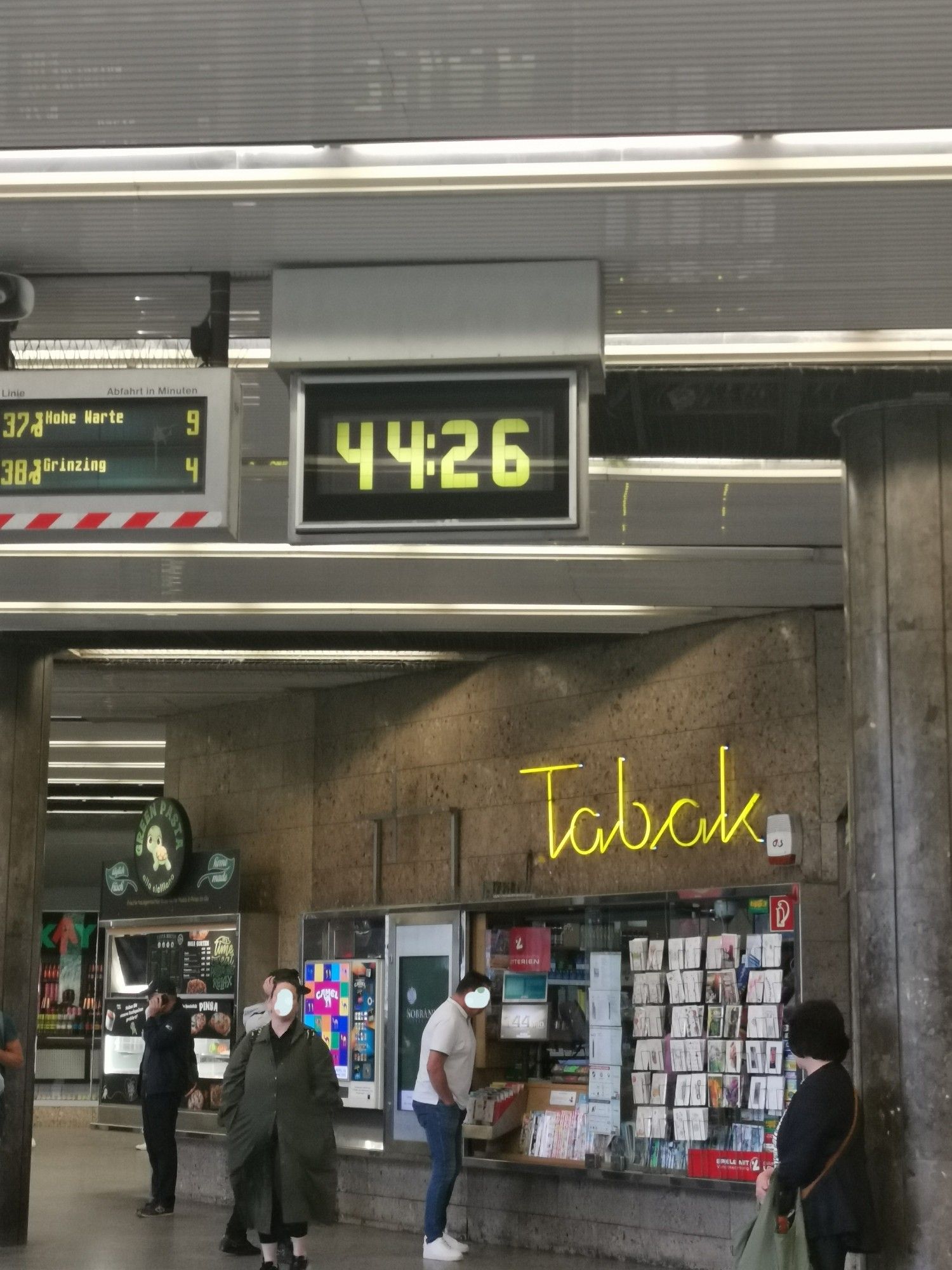 Das Besondere an diesem Foto einer Alltagsszene bei einer Straßenbahnstation (Schottentor) ist die Digitalanzeige der Uhr. Sie zeigt 44:26.