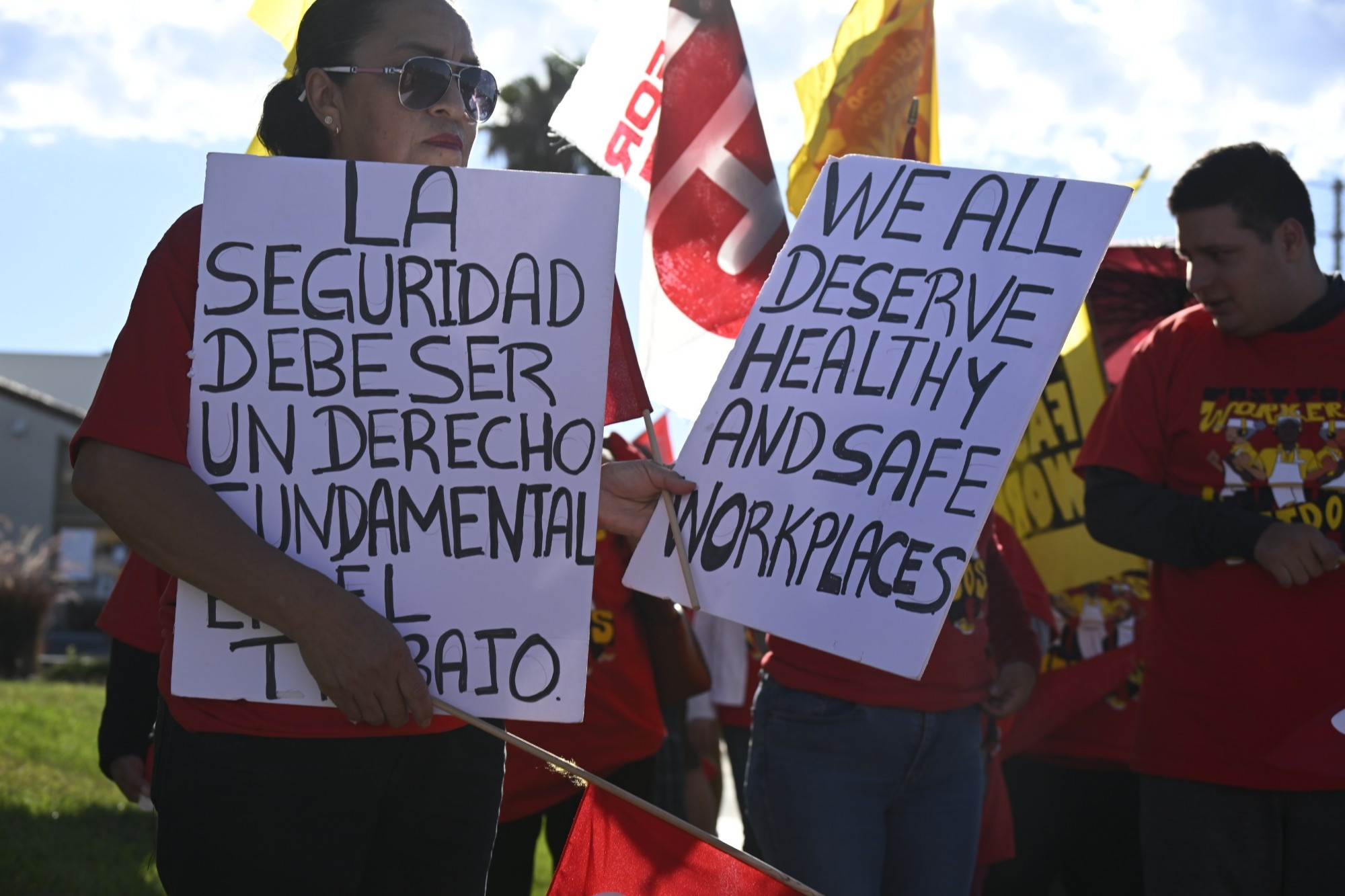 To workers march on the Wendy's holding signs to say we all deserve healthy and safe workplaces in English and Spanish