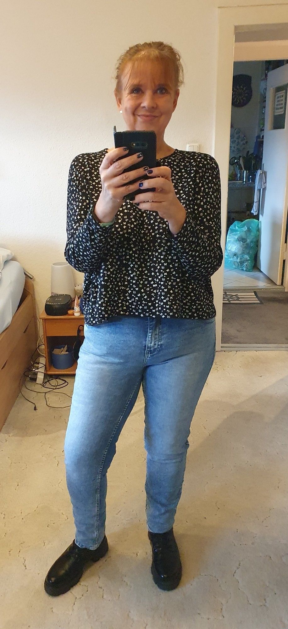 Spiegelselfie der Userin mit blauen Jeans, einem kurzen schwarzen Oberteil und schwarzen Boots.