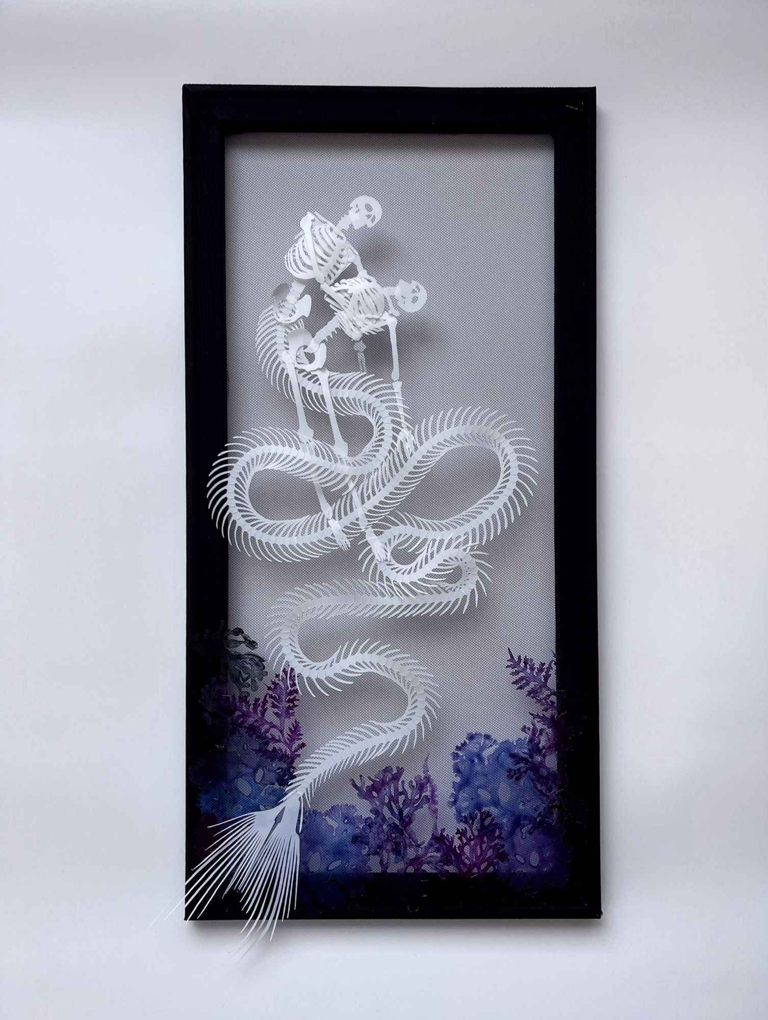 A mermaid skeleton with very long sinuous tail weaving around a swooning human skeleton beneath the sea, blue and purple seaweed and coral in the lower edges of the frame