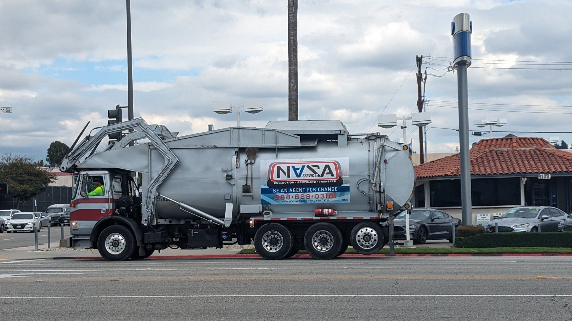 A vehicle marked NASA cruises a barren wasteland on an increasingly-developed yet still hostile planet