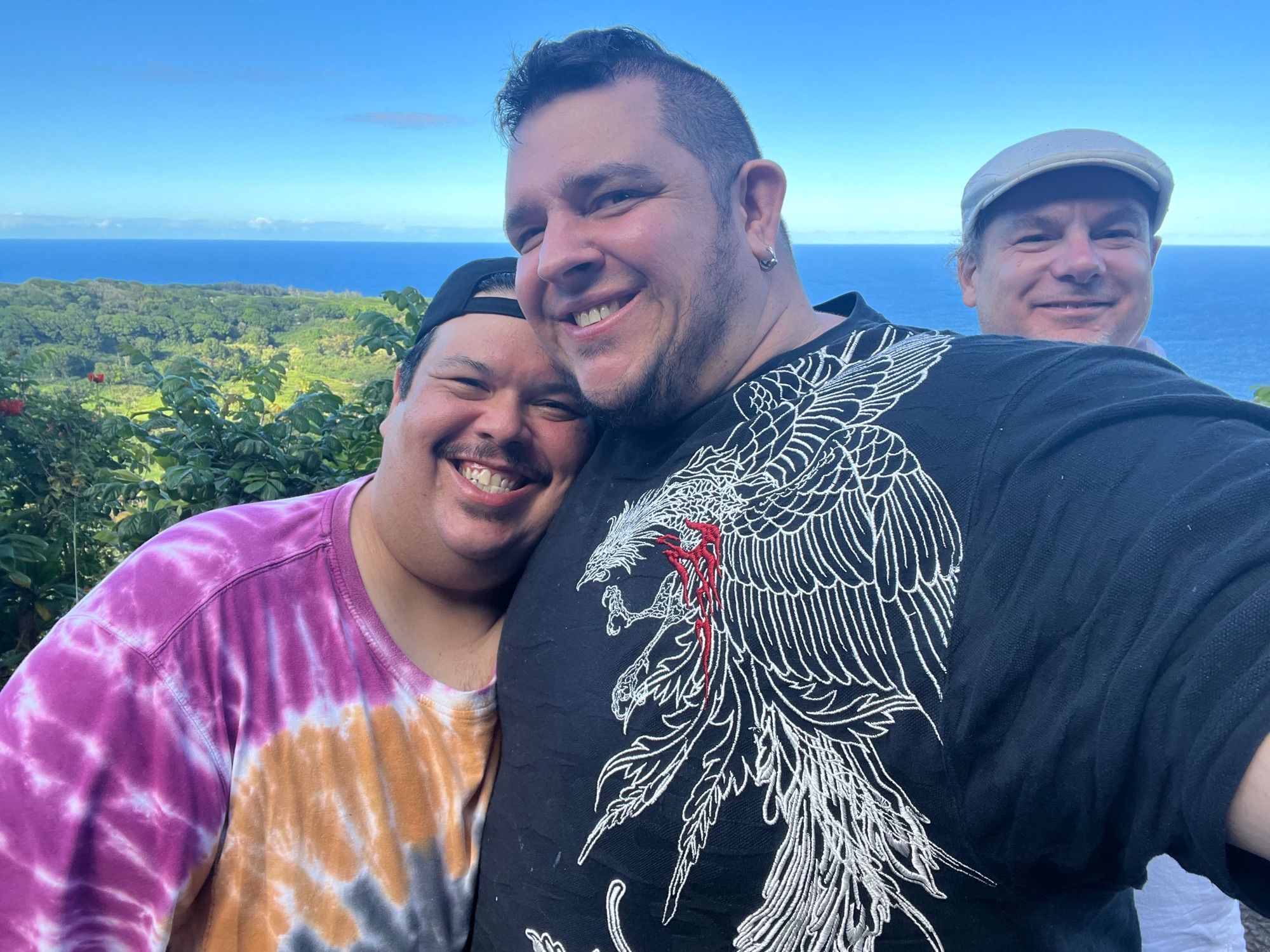 Myself, the boyf, and our friend Rhys on a stop by the road in front of a land and sea scape