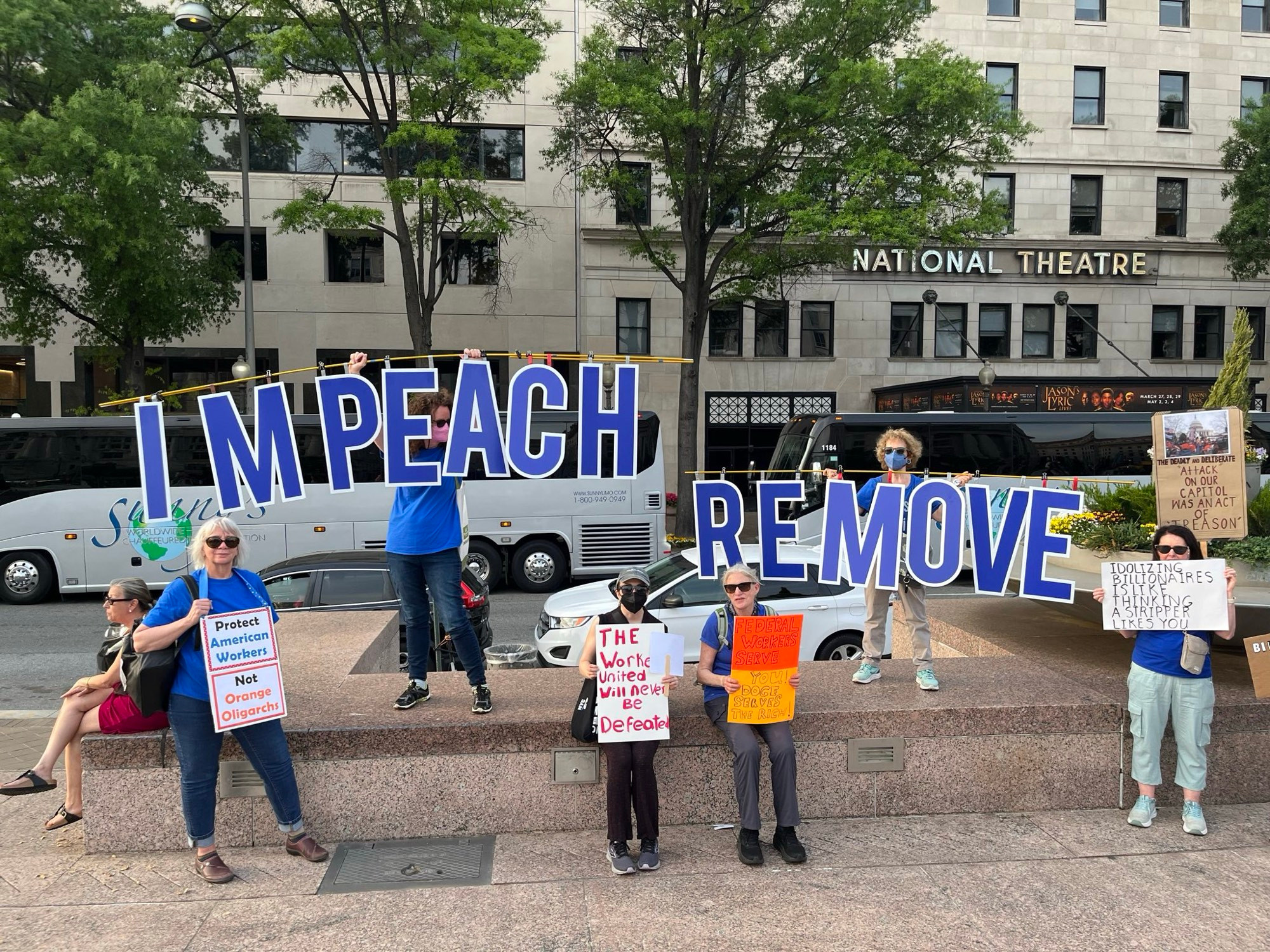 Activists hold sign IMPEACH REMOVE at Freedom Plaza DC