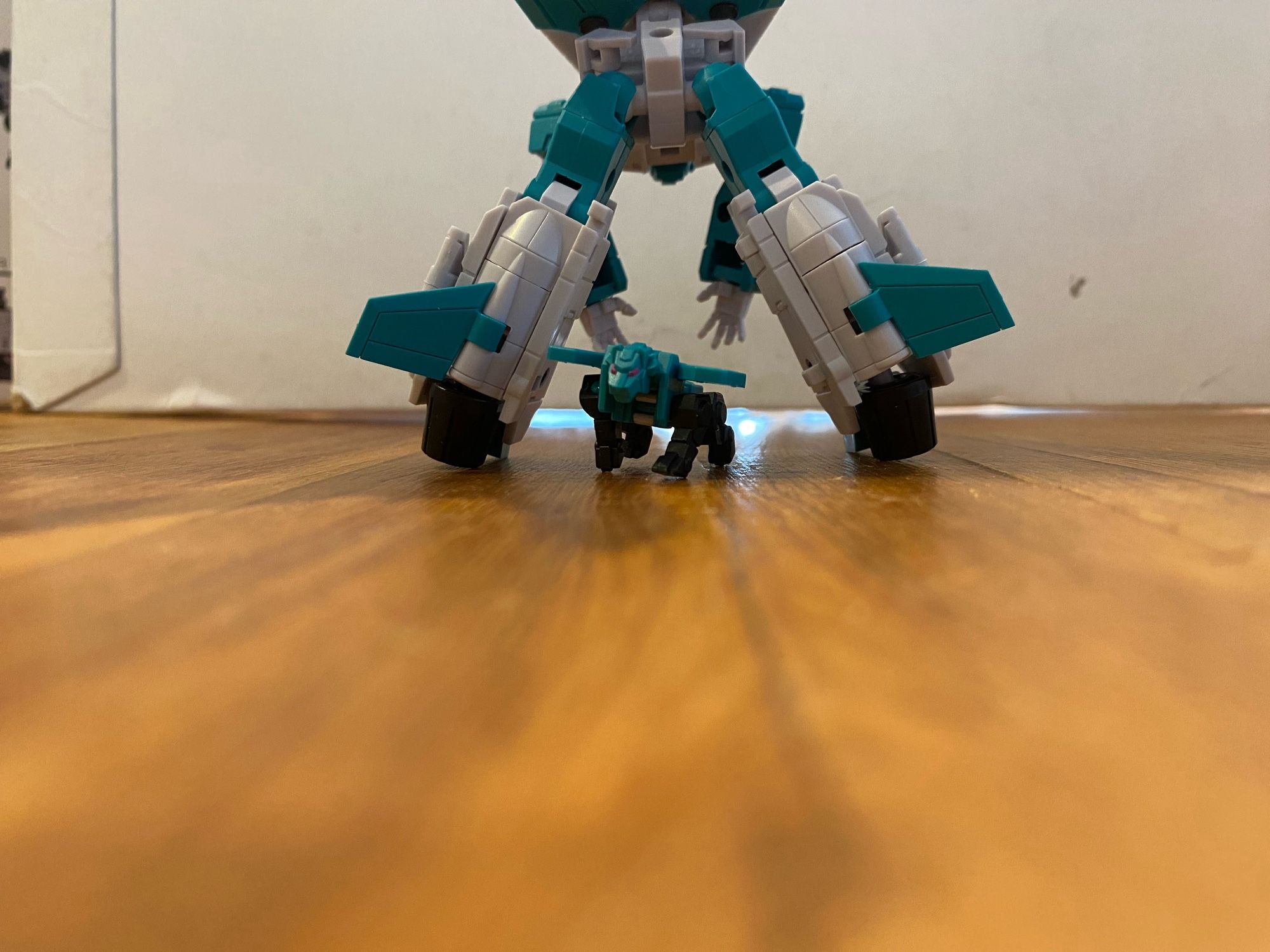 Image of the 3rd party action figure of the Transformers Breastforce character Leozack by Iron Factory. Leozack is bent over, with backside facing the camera, smelting to catch his lion companion.