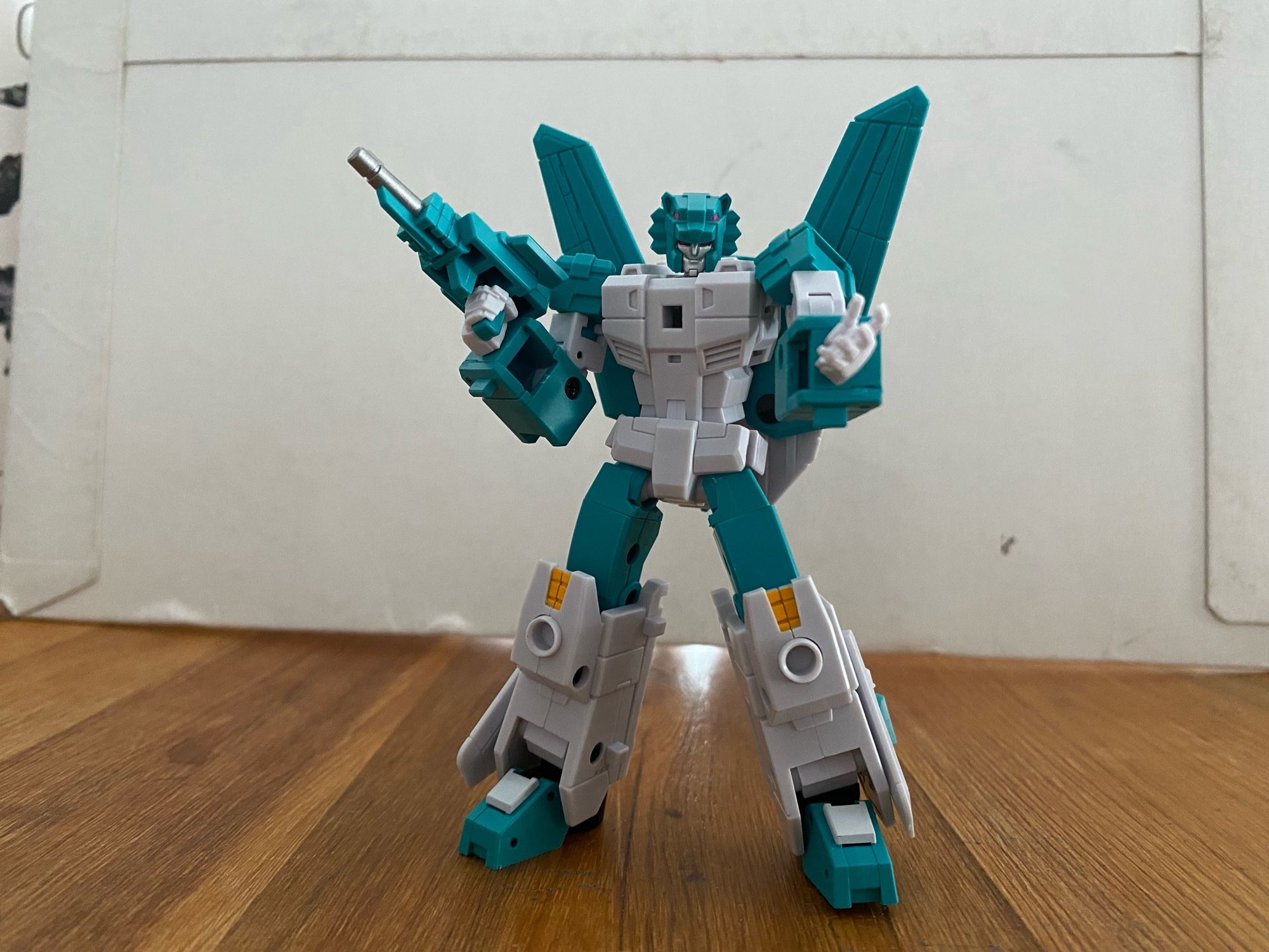 Image of the 3rd party action figure of the Transformers Breastforce character Leozack by Iron Factory. Leozack is holding his firearm in his right hand, with his left hand open and outstretched, a smirk on his face looking at the camera.