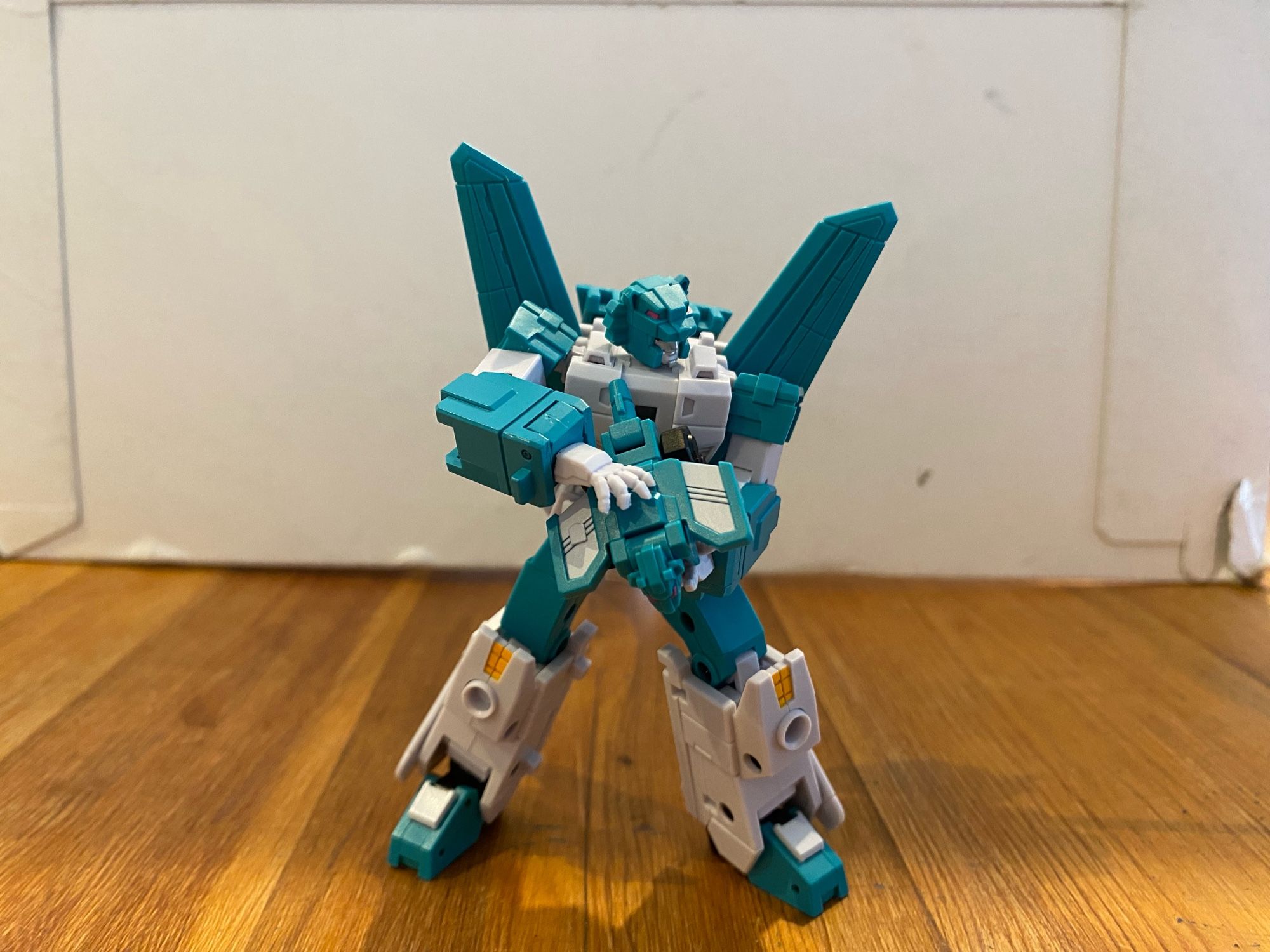 Image of the 3rd party action figure of the Transformers Breastforce character Leozack by Iron Factory. Leozack is holding his Breastforce partner lion in his hands, stroking it with his right. Leozack is looking off camera to the viewer’s right.