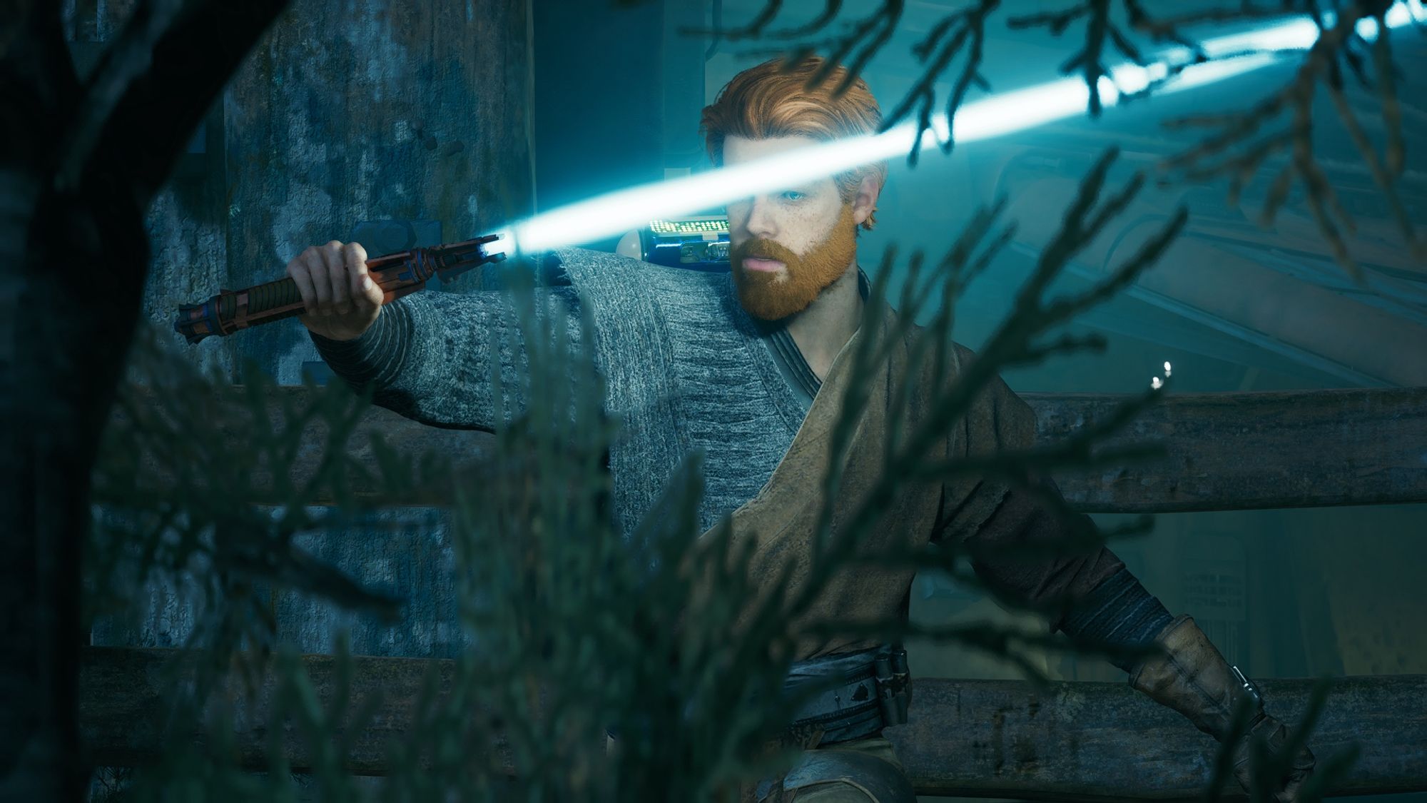 Screenshot from the game Star Wars Jedi Survivor, looking at the main character, Cal Kestis, through plant foliage. Cal is wielding a blue blade lightsaber, holding it nearly horizontal in front of him as if practicing a block. Cal is wearing a dark gray woollen outfit accented with a beige linen tunic. Cal has a full beard and luscious hair.