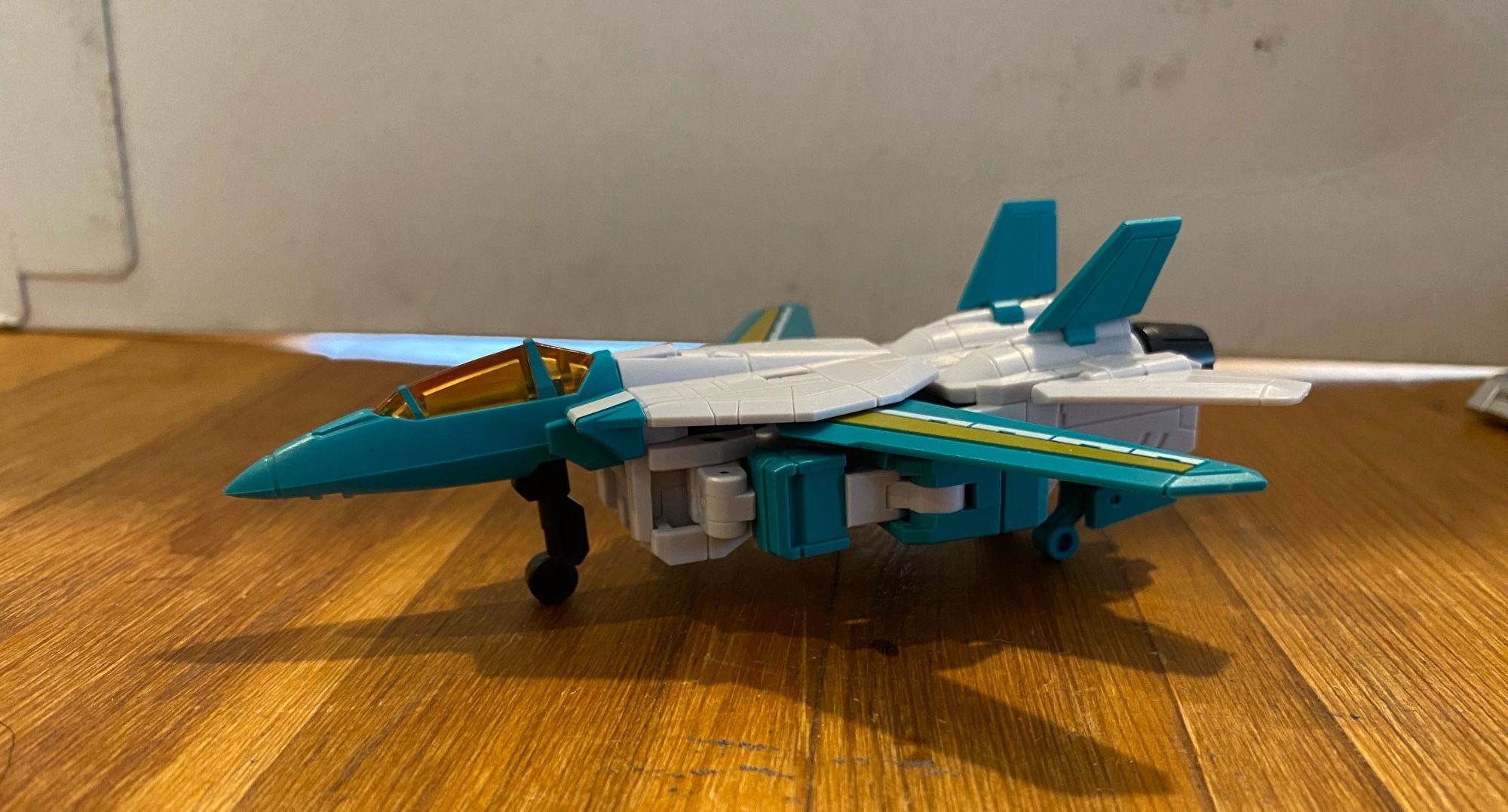 Image of the 3rd party action figure of the Transformers Breastforce character Leozack by Iron Factory. Leozack is in his jet mode, pointing off camera to the viewer’s left.