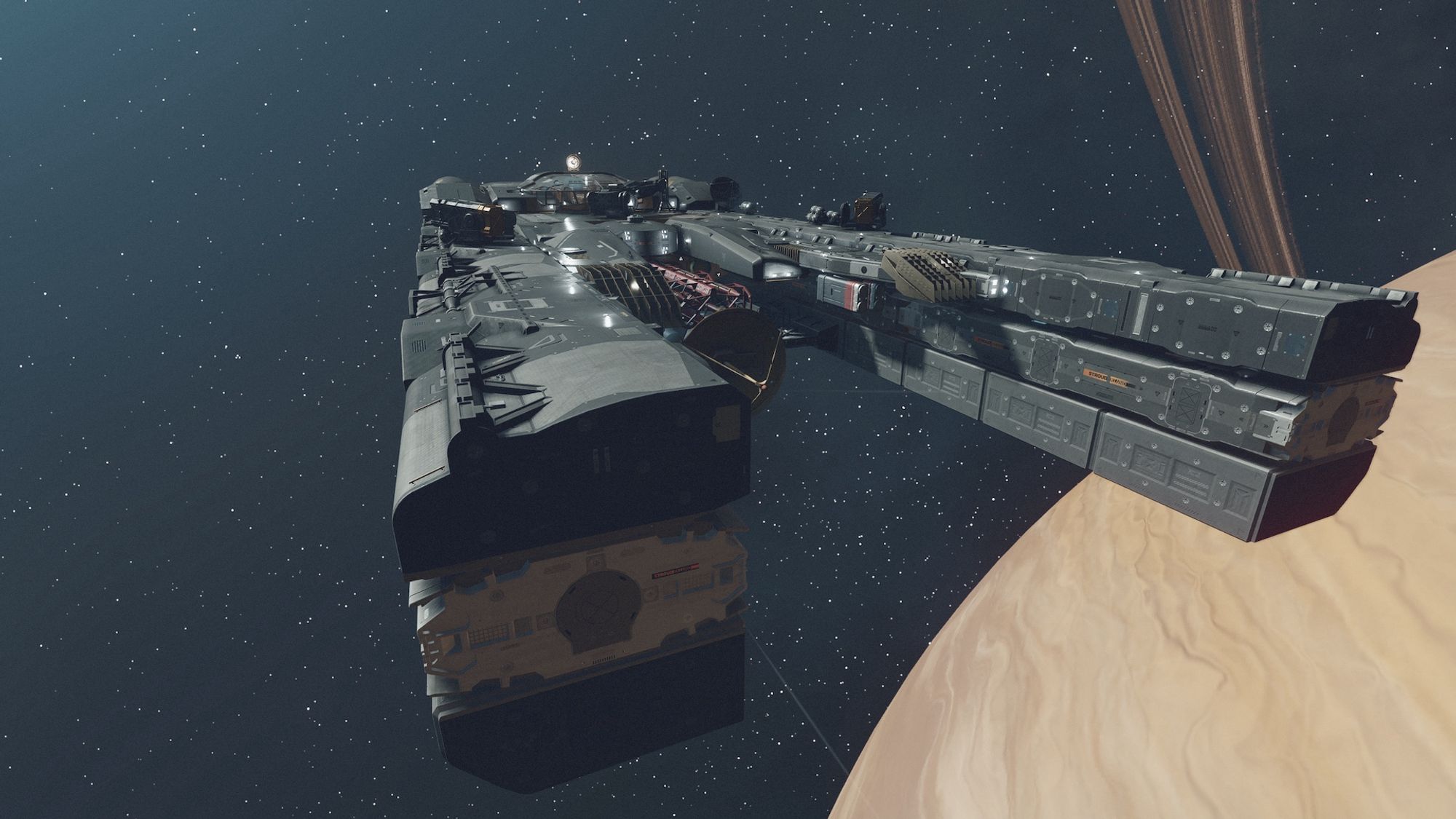 Screenshot from the game Starfield centring on a large grey starship flying through space, towards the camera, above a large ringed yellow planet.