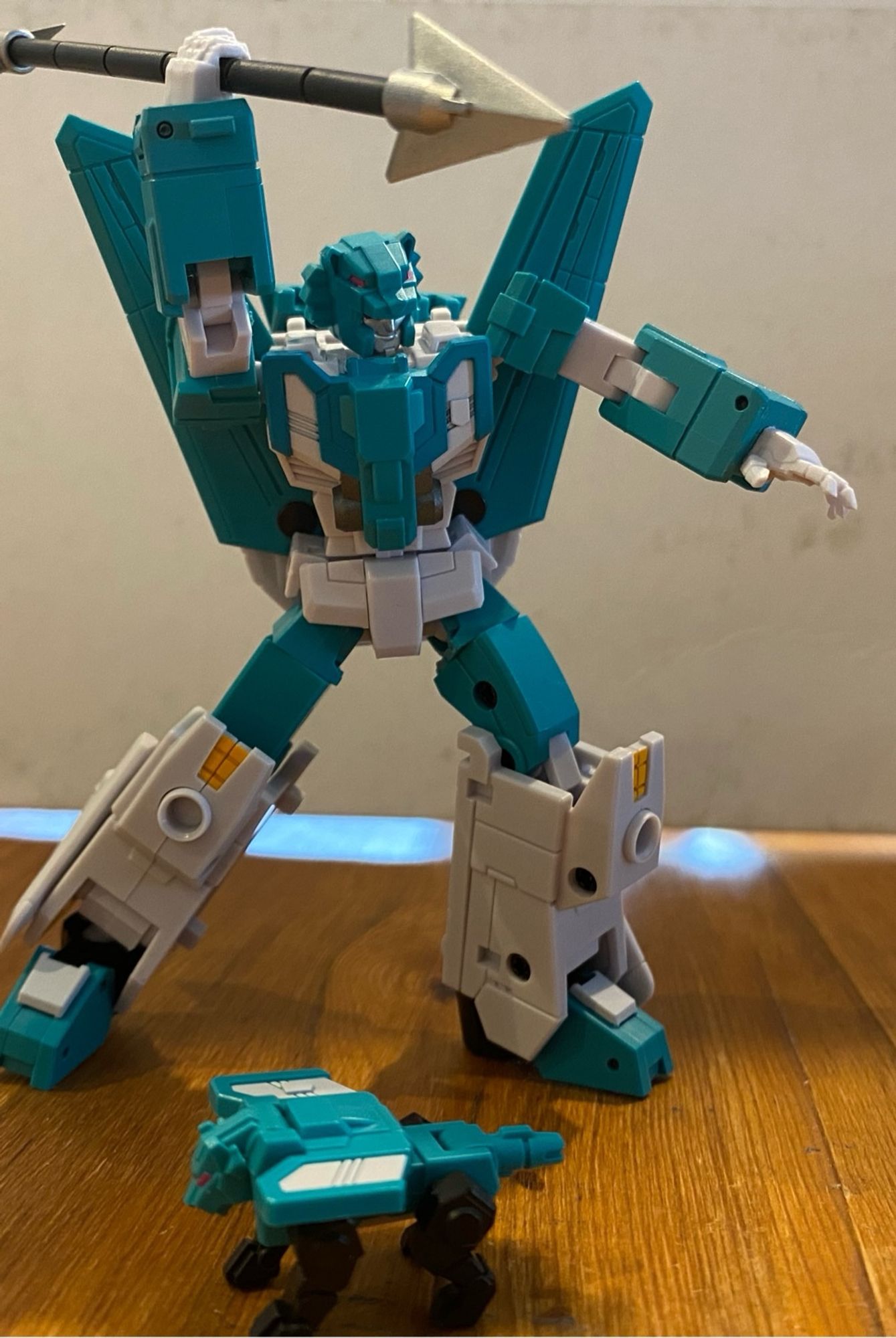 Image of the 3rd party action figure of the Transformers Breastforce character Leozack by Iron Factory. Leozack is holding one arm above his head holding a spear like weapon aiming it and looking at something off camera. His lion companion is stood in front of him looking off in the opposite direction.