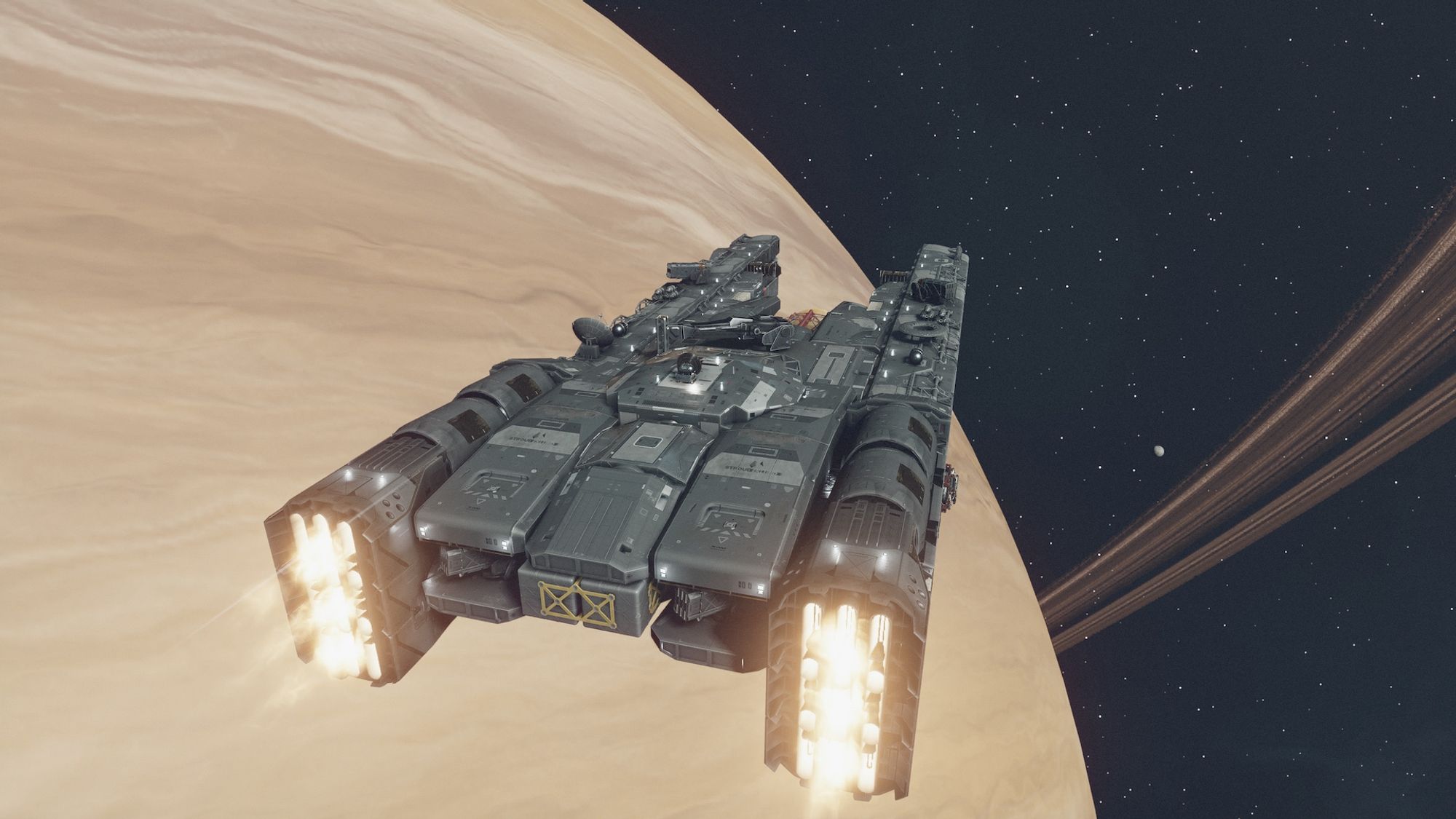 Screenshot from the game Starfield centring on a large grey starship flying through space, away from the camera, above a large ringed yellow planet.