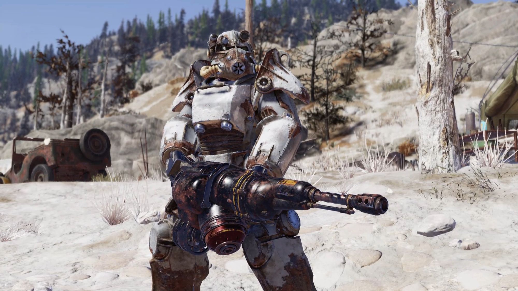 Screenshot from the game Fallout 76 centring on the player character , wearing a suit of T45 power armour and stood in a sandy gray wasteland. A makeshift tent and jeep are visible in the background. The player character is also holding a large, heavy barreled weapon.