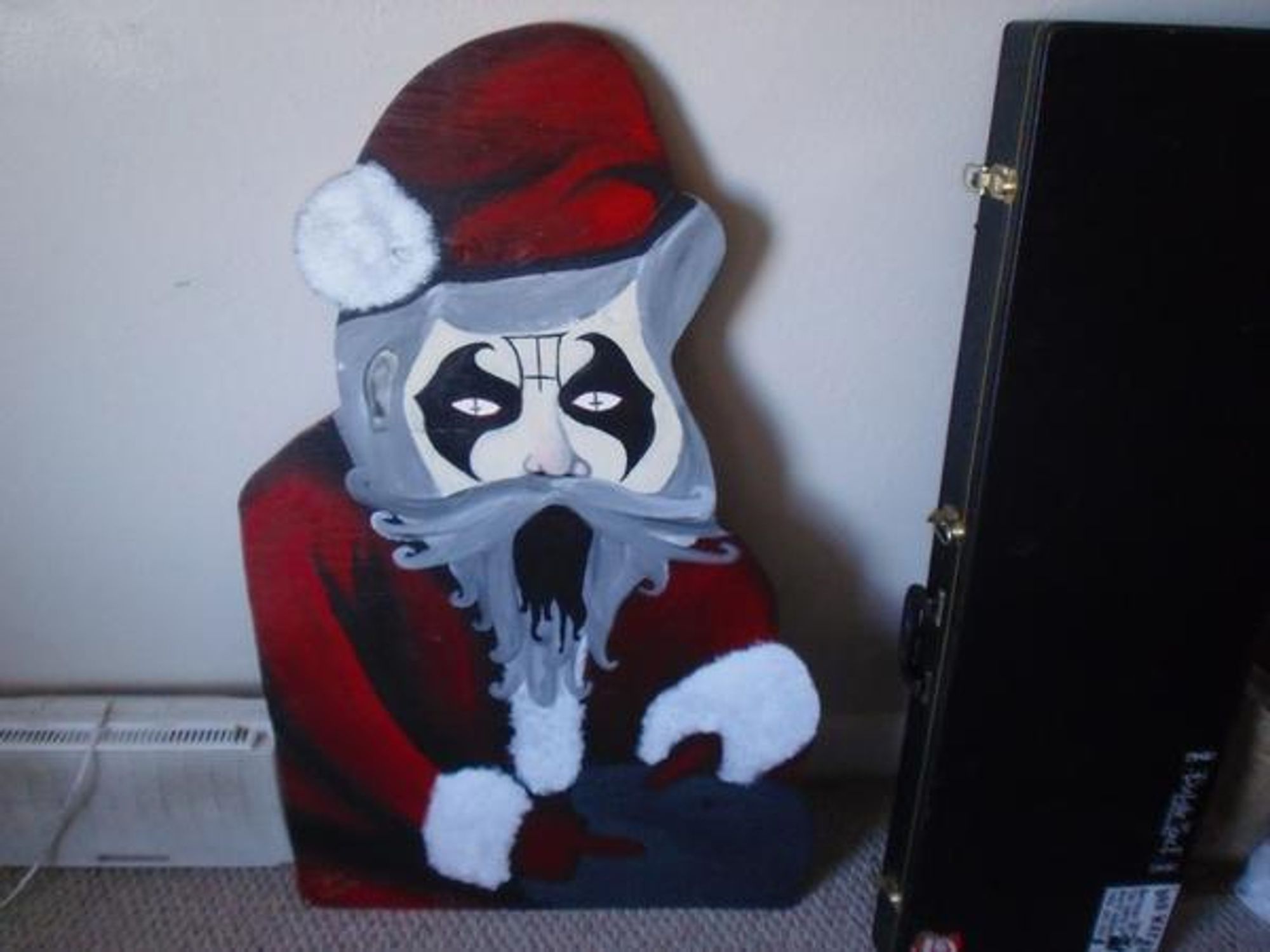 A King Diamond corpse painted Wooden Santa. Festive for the Holidays. Might be a middle finger in there.