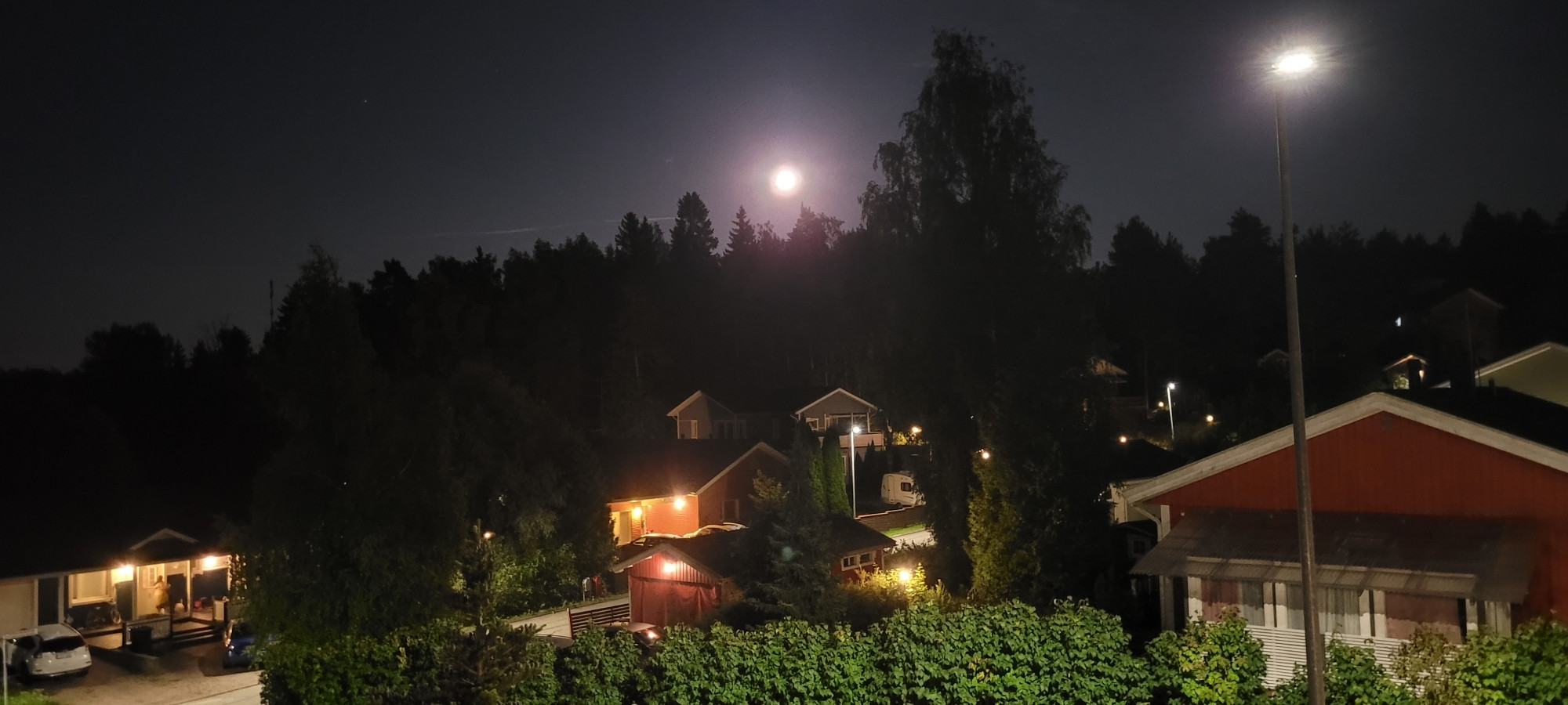 The same moon rising over a wooded suburban neighbourhood west of Helsinki, Finland