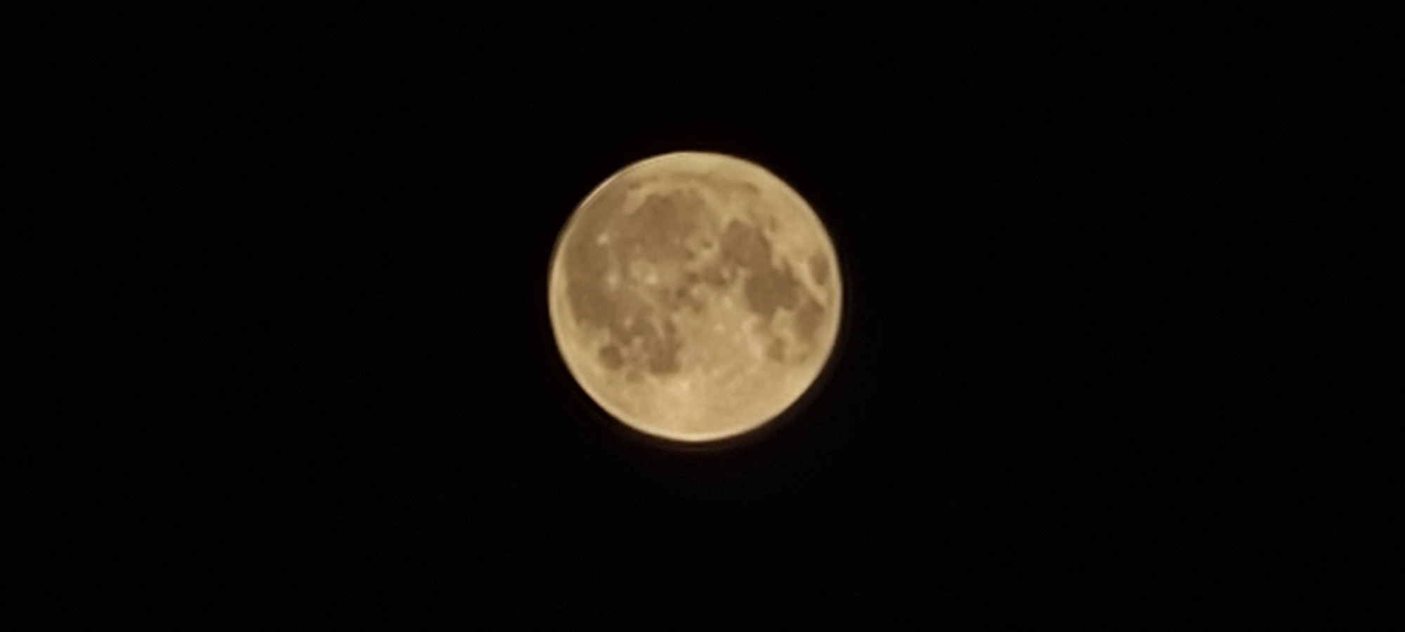 Full moon, close up and gold, with visible topography