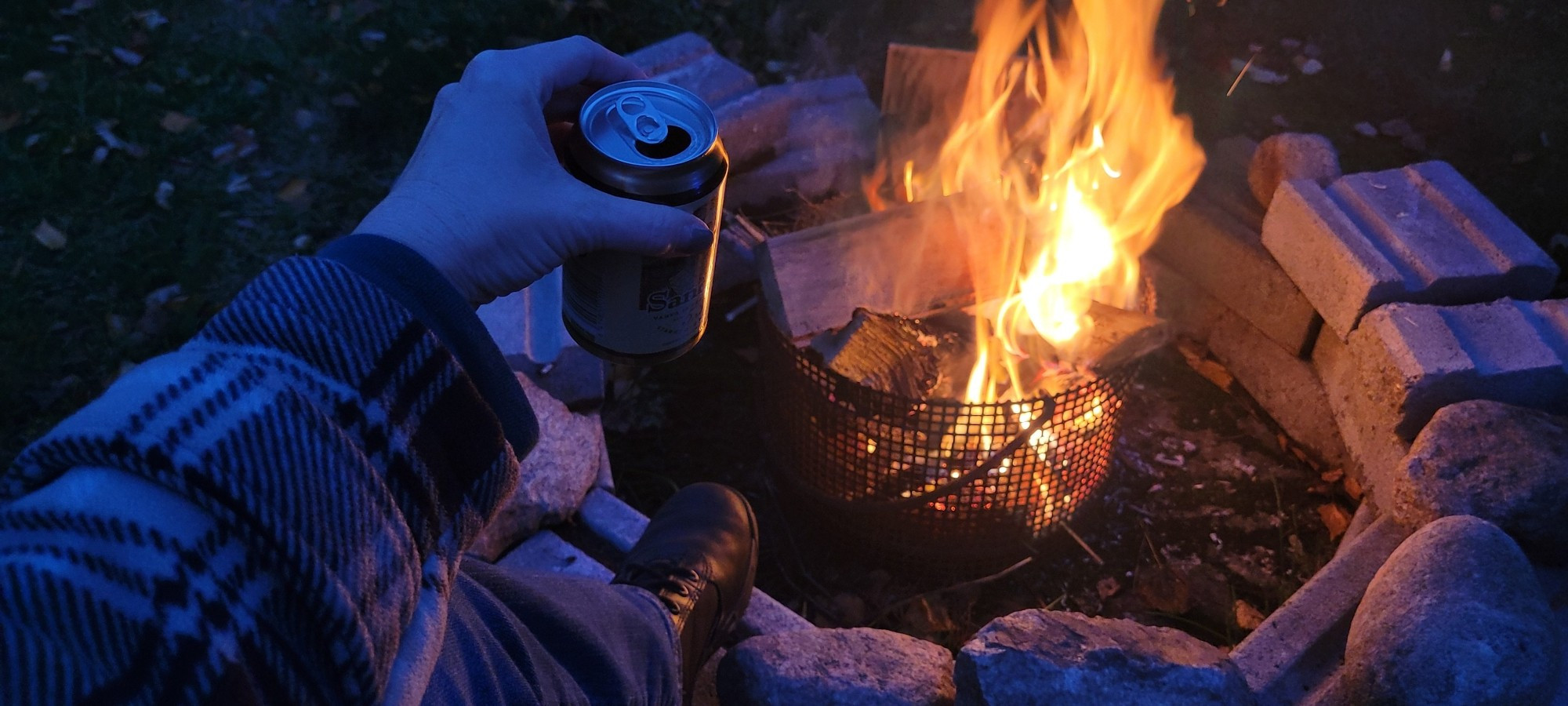 It's almost fully dark and we have a little campfire going in the yard. I'm supportive with my feet propped up on the stove and a beer in my hand