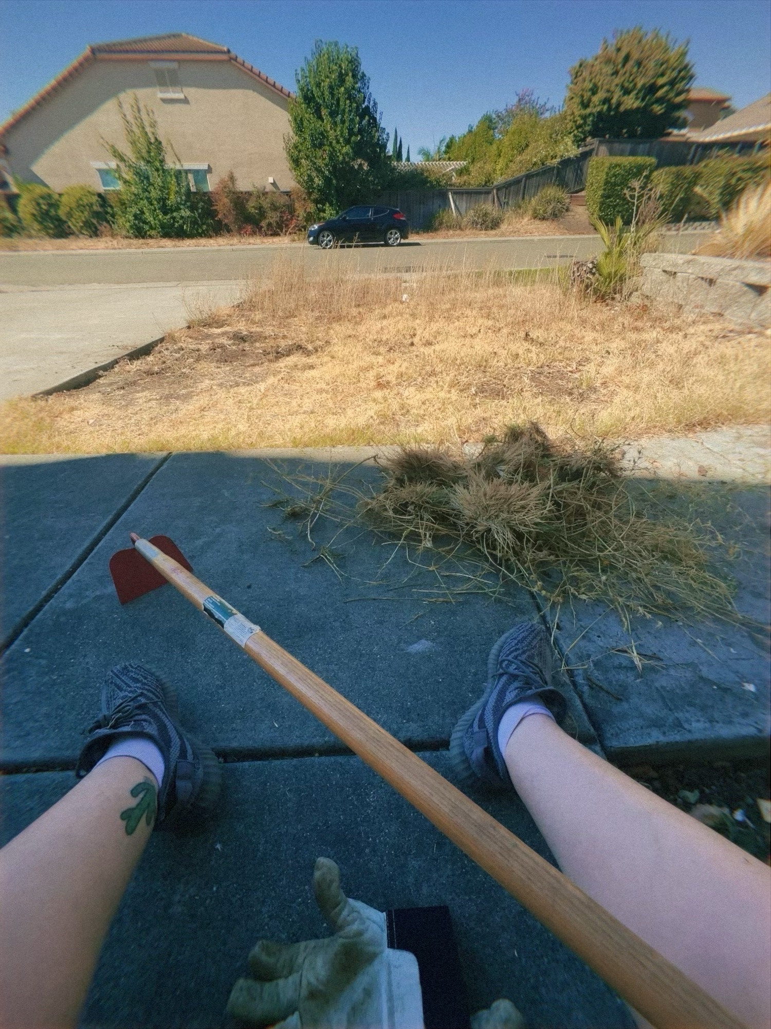 a picture of chaps’ feet with a super dead grass lawn in front of them.