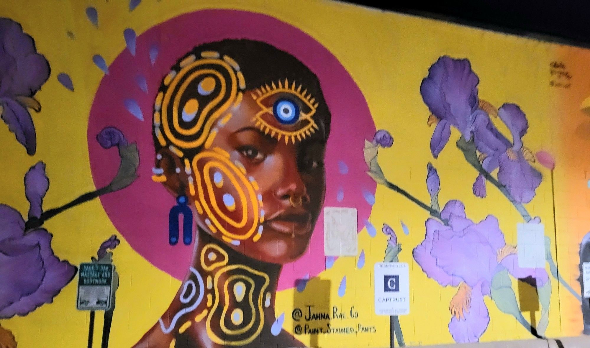 A colorful image of a Black woman on a yellow wall