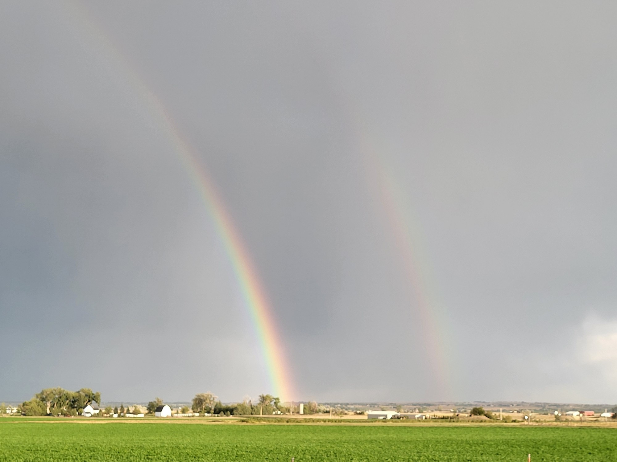 A double rainbow over a green field