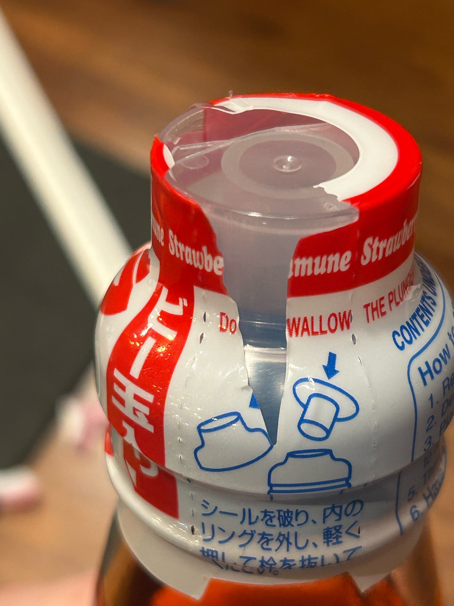 Torn ramune cap wrapper with focus on the text “Do     WALLOW”