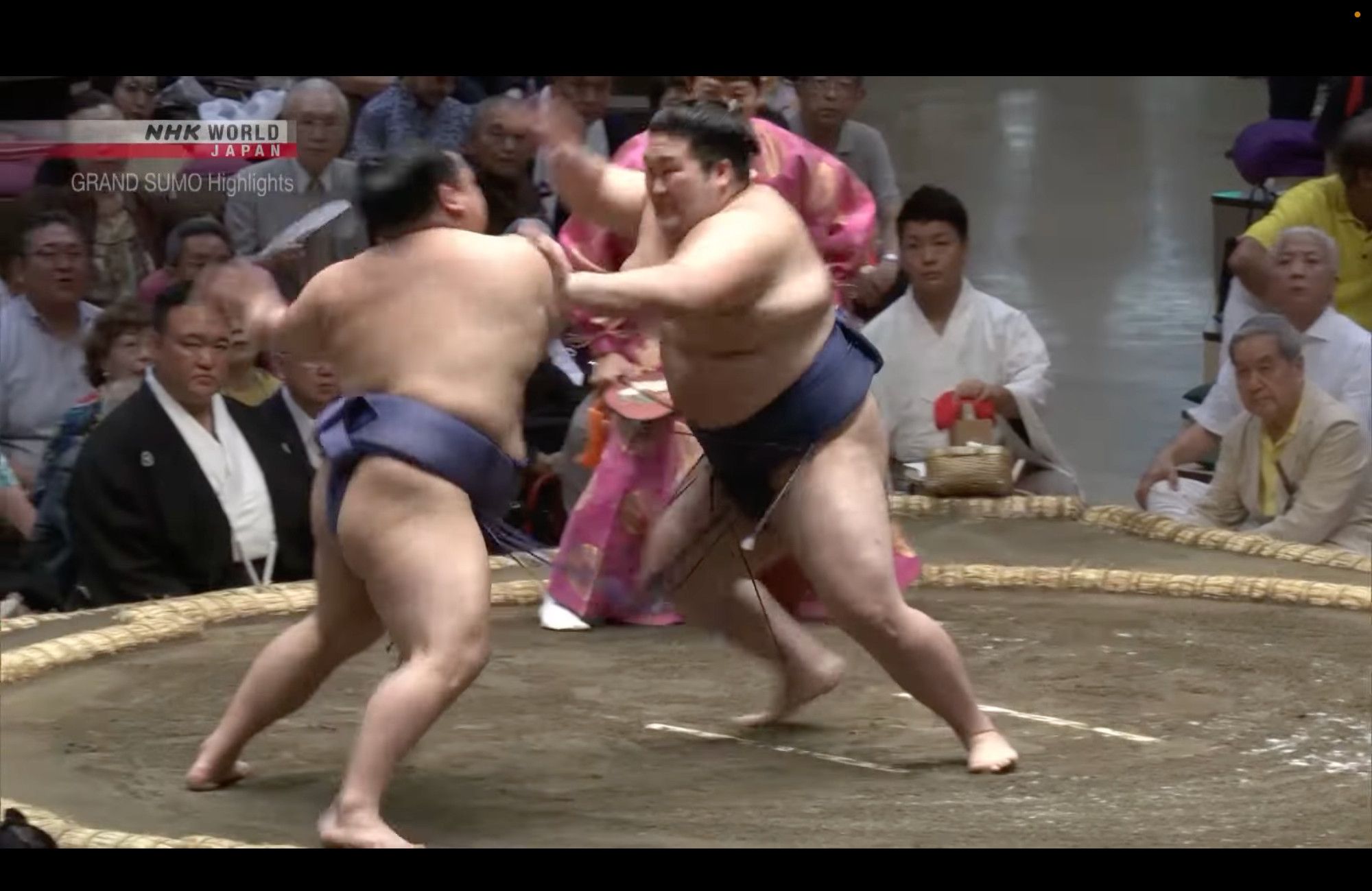 A sumo wrestler attacks his opponent with suppari thrusts