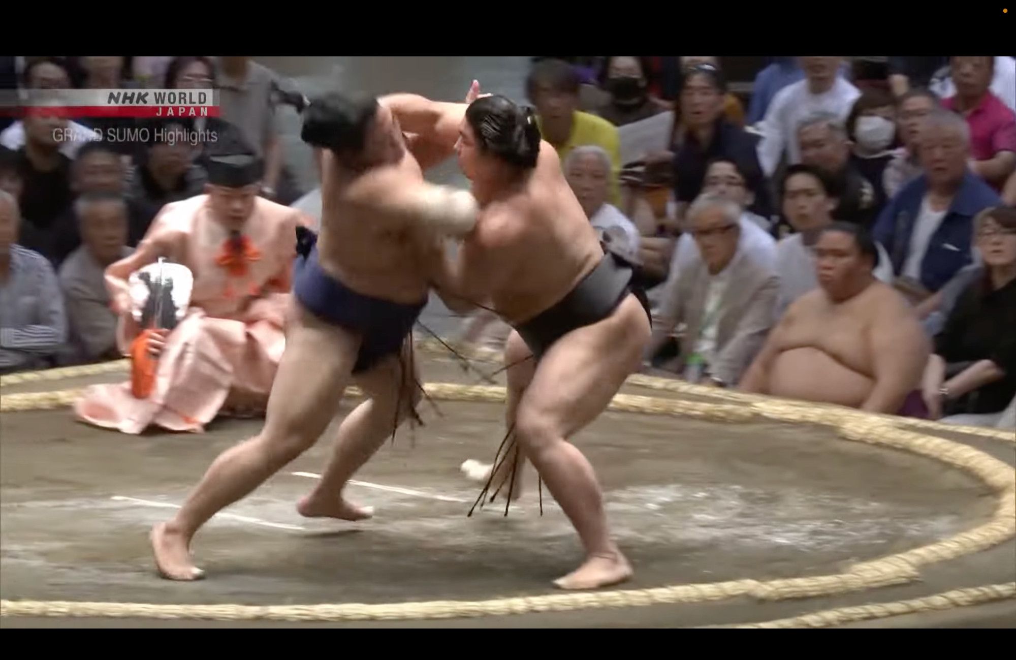 Sumo wrestler Hiradoumi subdues Wakamotuharu by taking a left underhook