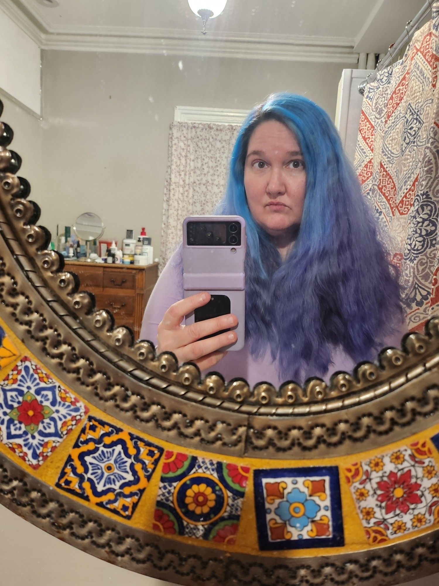 selfie in Mexican talavera mirror of me in February with peak hair, pretty long, wavy, blue->purple ombre,  TOTALLY ungovernable for the most part