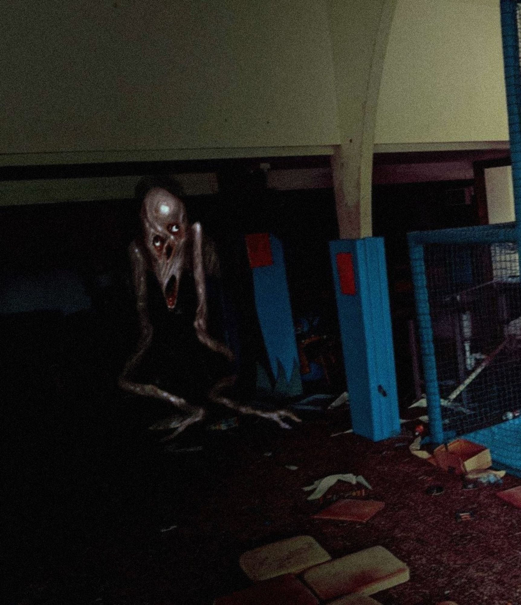 a drooping thing with long arms crawls out of hiding in an abandoned play centre