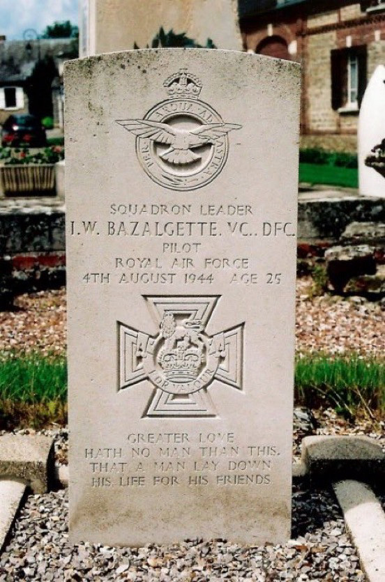 Ian Bazalgette’s headstone in Senantes Churchyard.
📷 memorialstovalour.co.uk

(Discoloured white stone headstone set in gravel, marked with an engraving of the Victoria Cross. The personal inscription reads “Greater love hath no man than this, that a man lay down his life for his friends”)