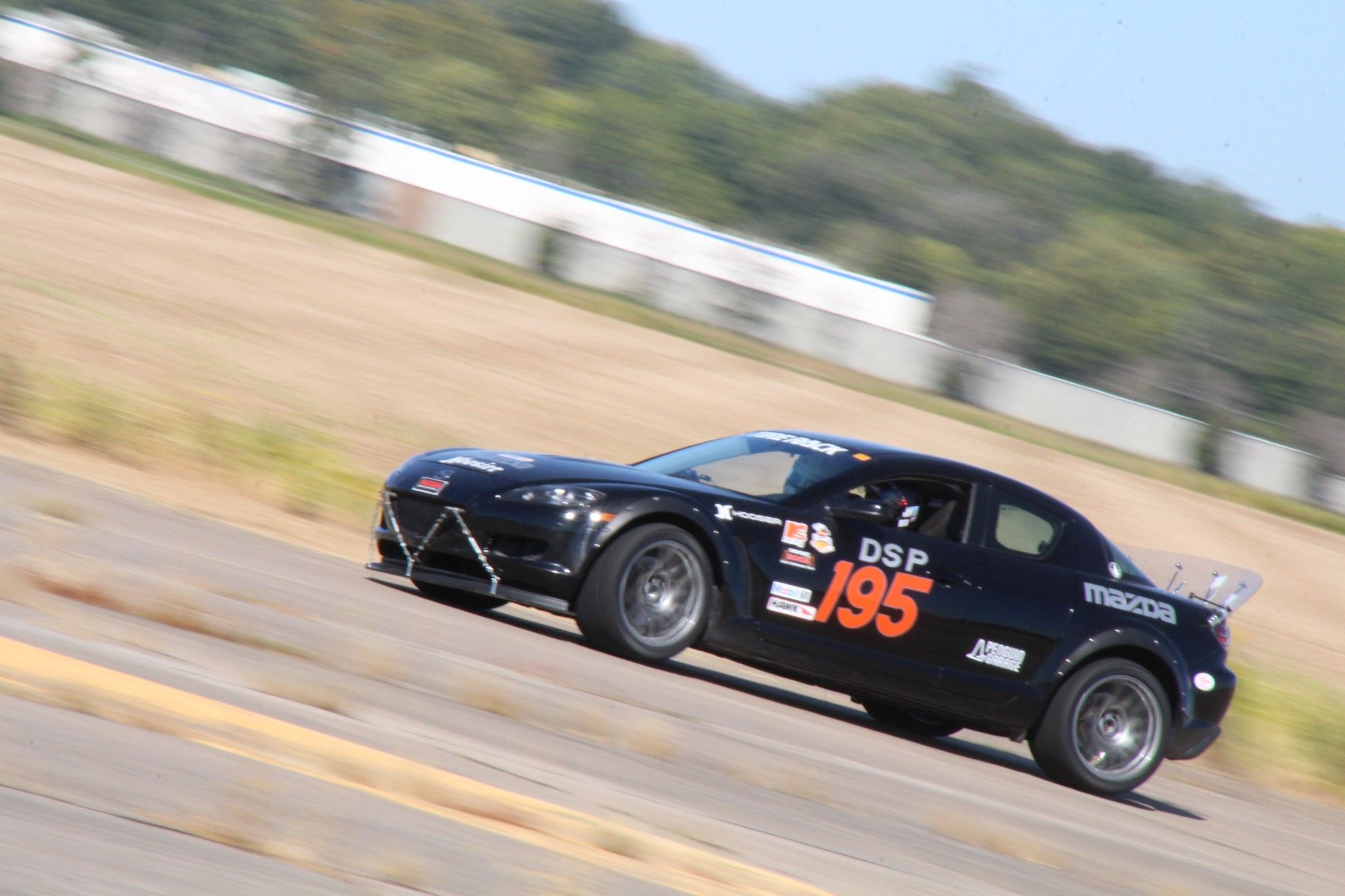 A black Mazda RX-8 racing on course.