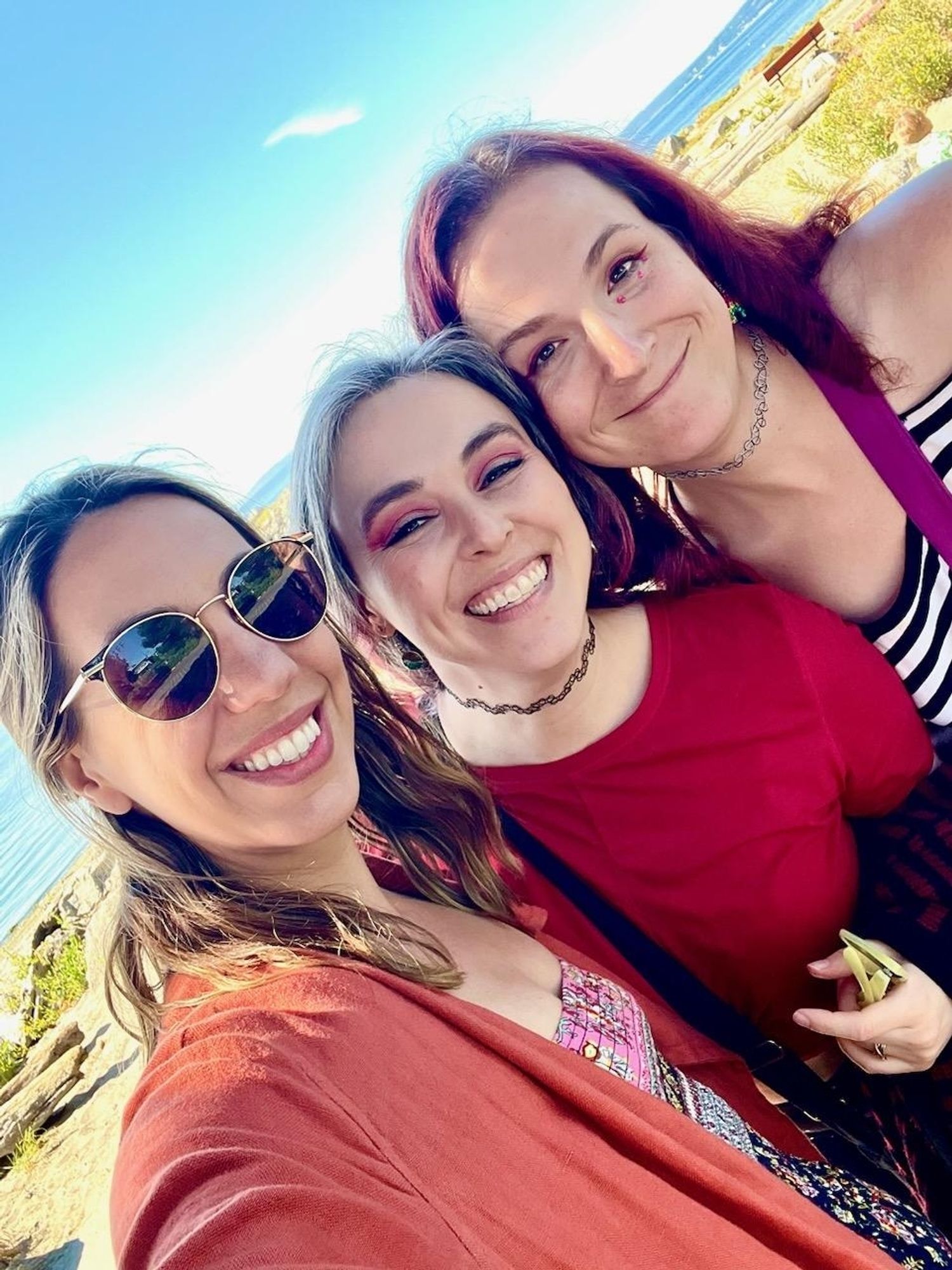 Jessie Meghan and Jordan smiling in a sideways photo in front of the Puget Sound!