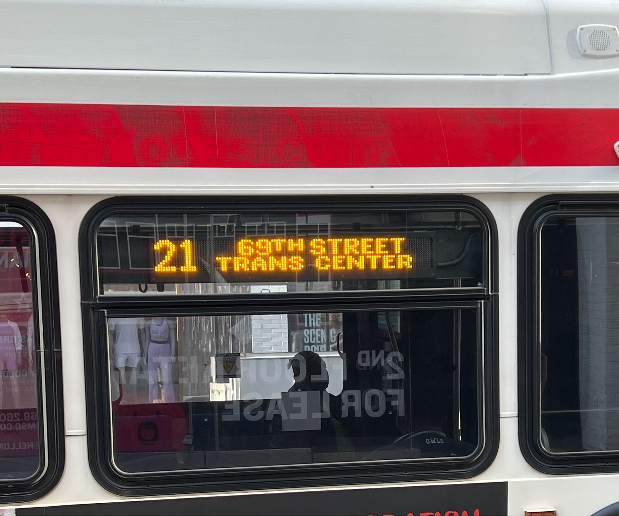 Photo of the side of a bus. LED readout in orange reads “69th Street Trans center”