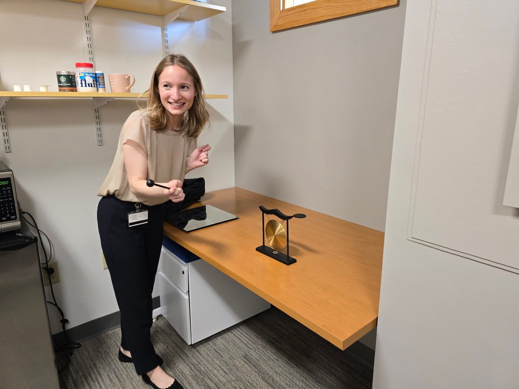 Maren celebrating by ringing the lab gong.