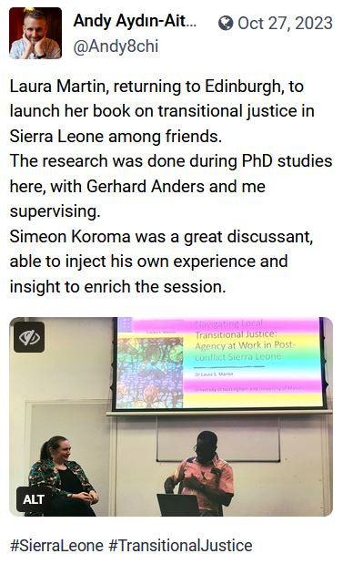 Picture of Dr Laura Martin in discussion with Dr Simeon Koroma. The Post it is in mentions her work on Sierra Leone and transitional justice. 