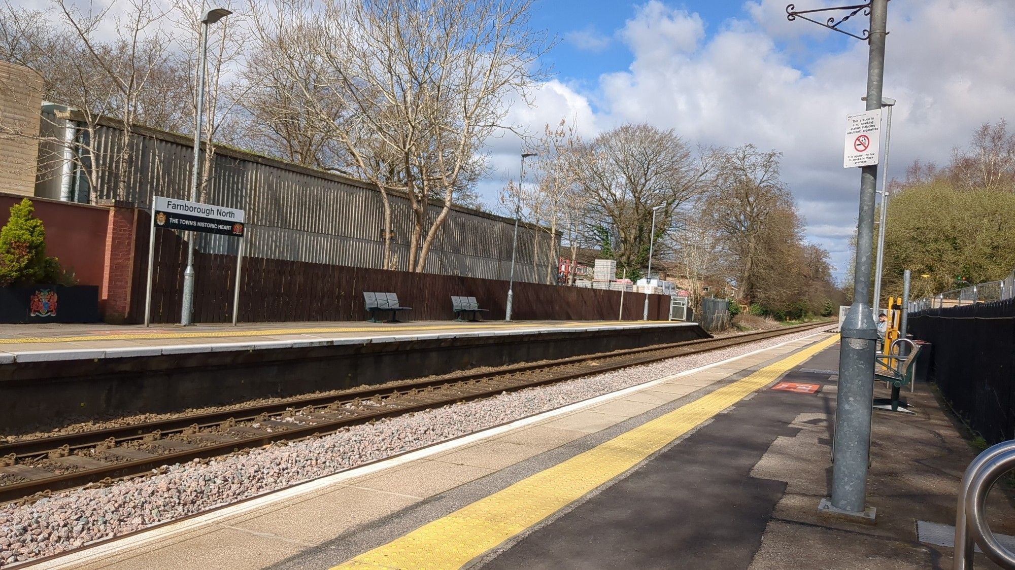 Photo of a open two track trainstation, Farnborough north, in the sun, with no one there (except for me, but I'm taking the photo so I'm not visible)