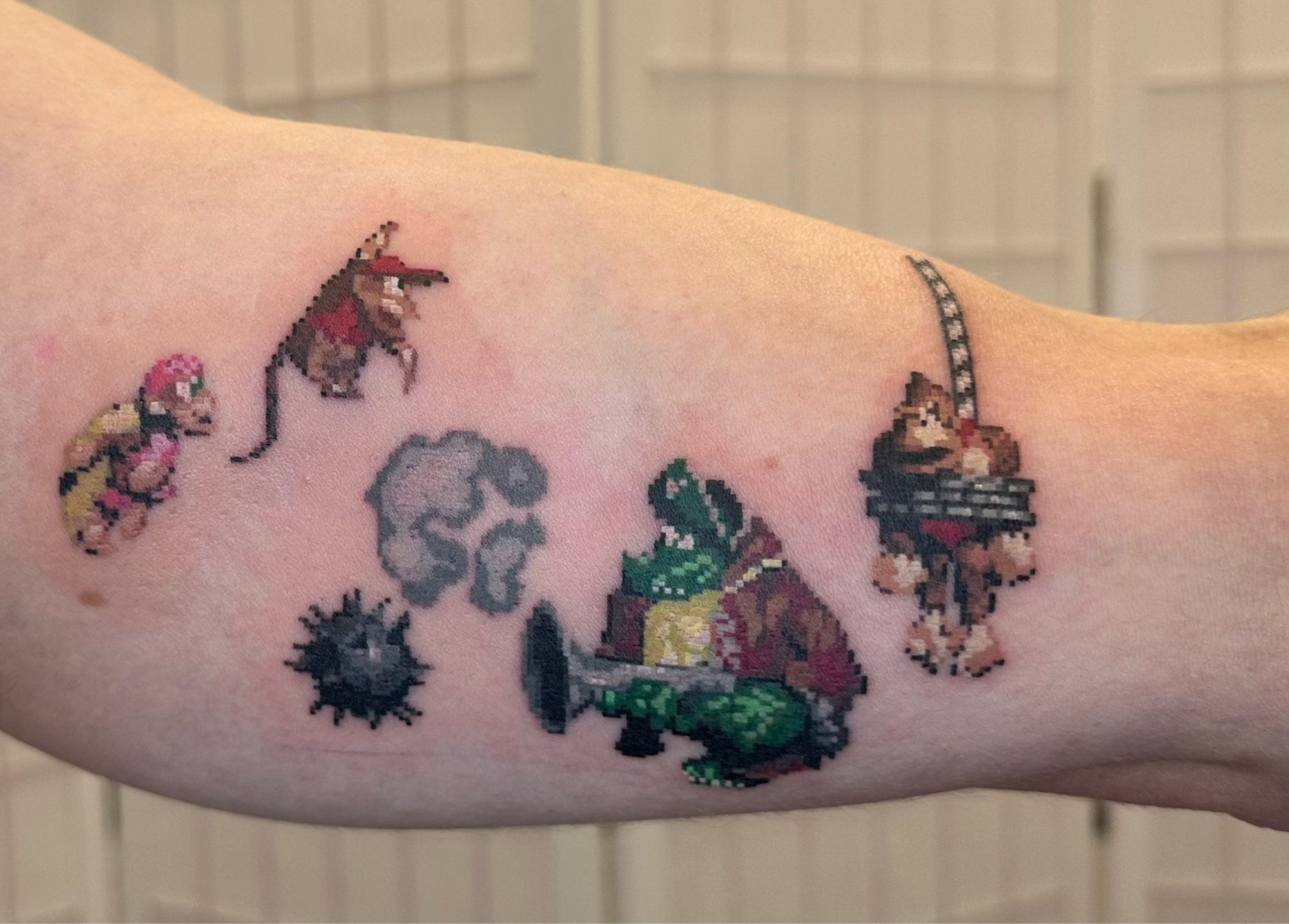 A pixel art tattoo of Dixie Kong, Diddy Kong, Kaptain K.Rool and Donkey Kong