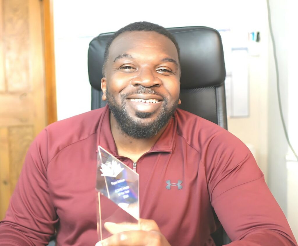 Dr Ryan Arthur holding a trophy for winning the Article of the Year Award by the Journal of Learning Development in Higher Education.