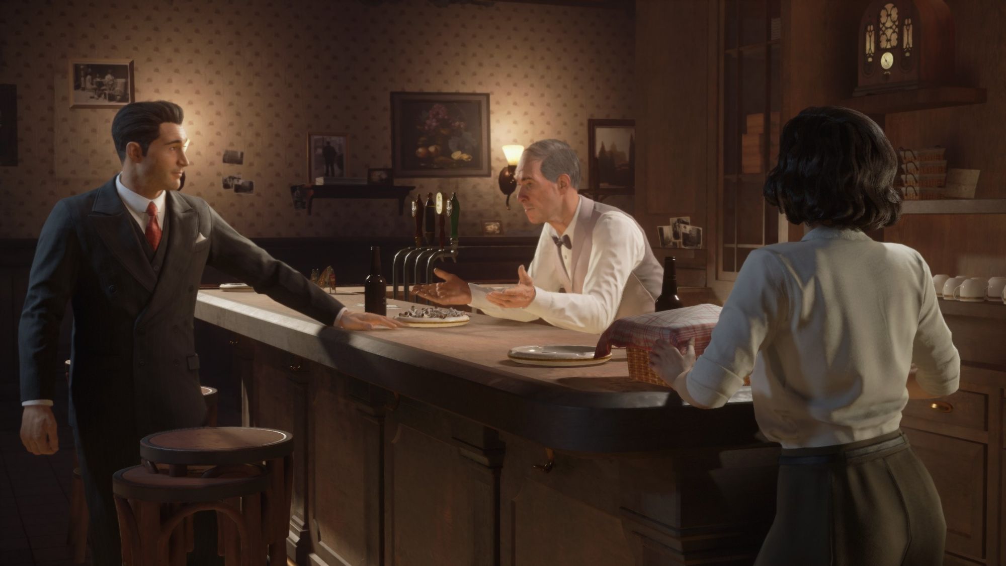 A screenshot from Mafia featuring the main character, white man black suit and red tie leaning a hand on a bar talking to a older man in a white shirt and grey vest and a woman in a green shirt and white shirt