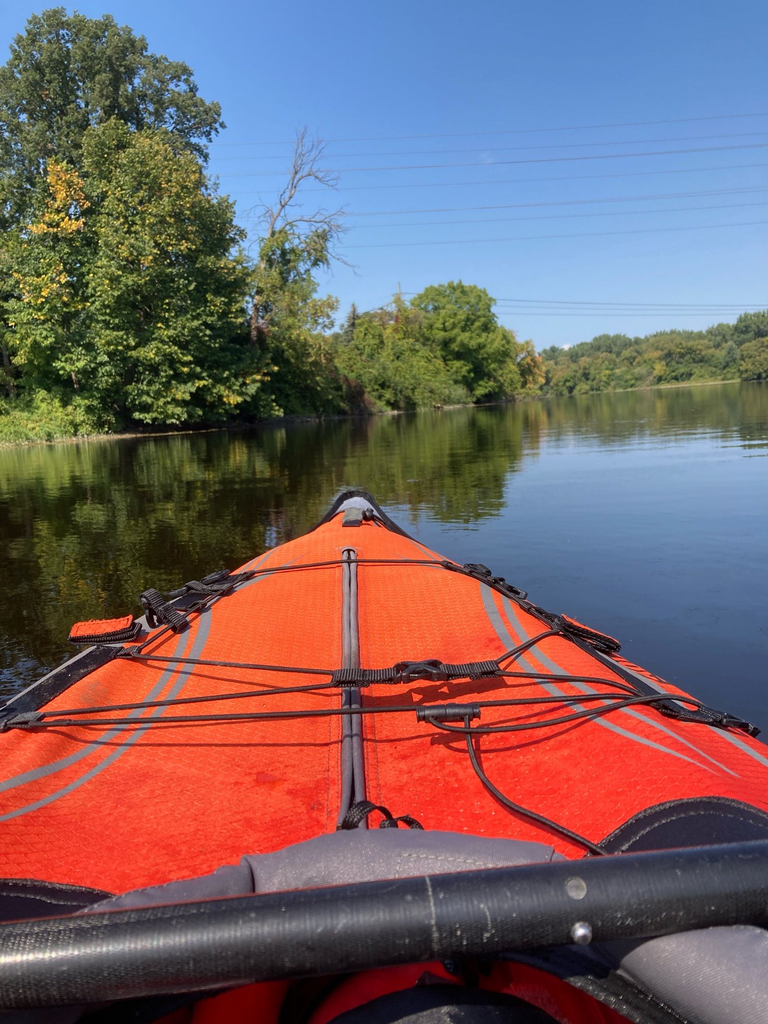 Coloured photo of my orange inflatable kayak on the Rideau River.