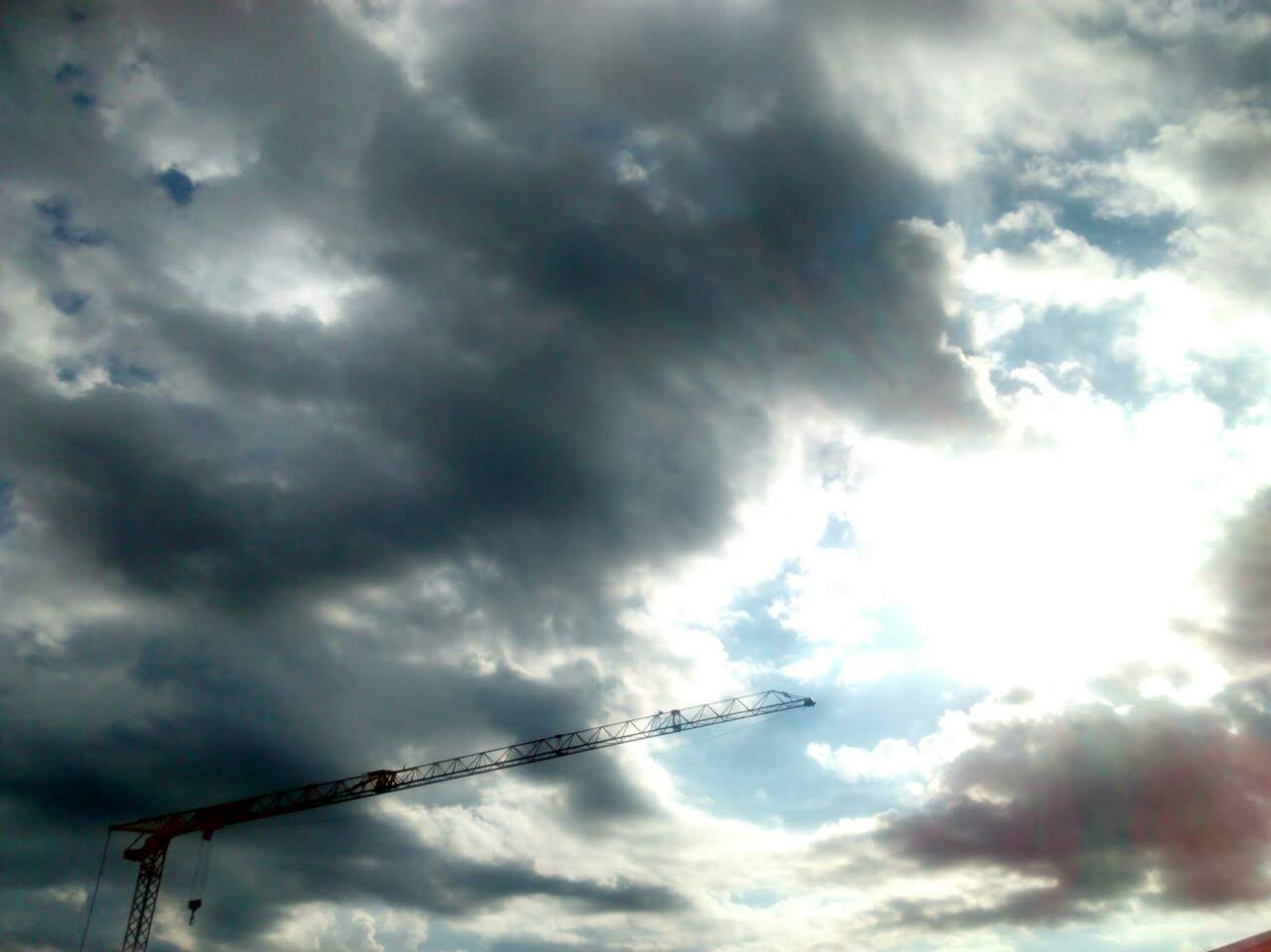 Graue Wolken und zwischendrin eine hellblau-weiße Öffnung mit Lichtblick.