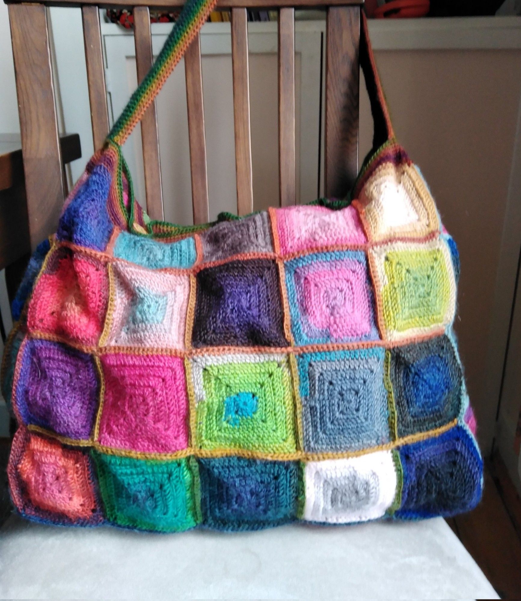 Large bag made of different coloured granny squares

This bag is big enough to hold everything I need for my crochet classes; sample pieces, handouts, equipment and yarn