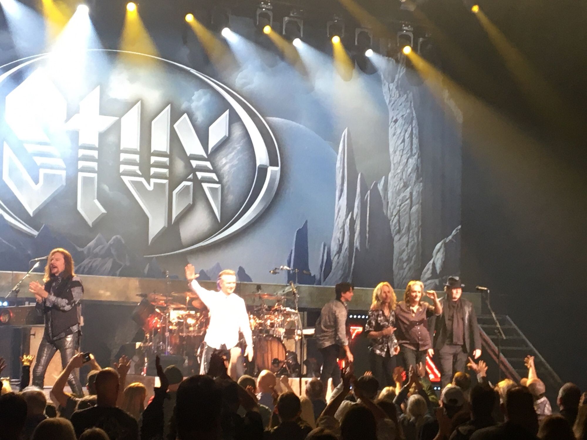 Members of the band Styx taking in the applause on stage at the end of their performance.