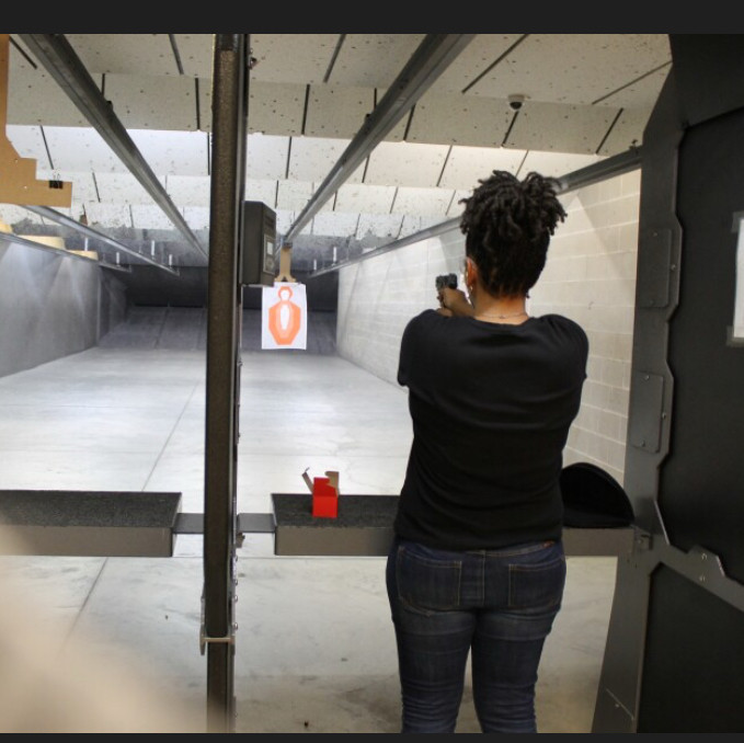 Woman at the gun ranging aiming at a target 