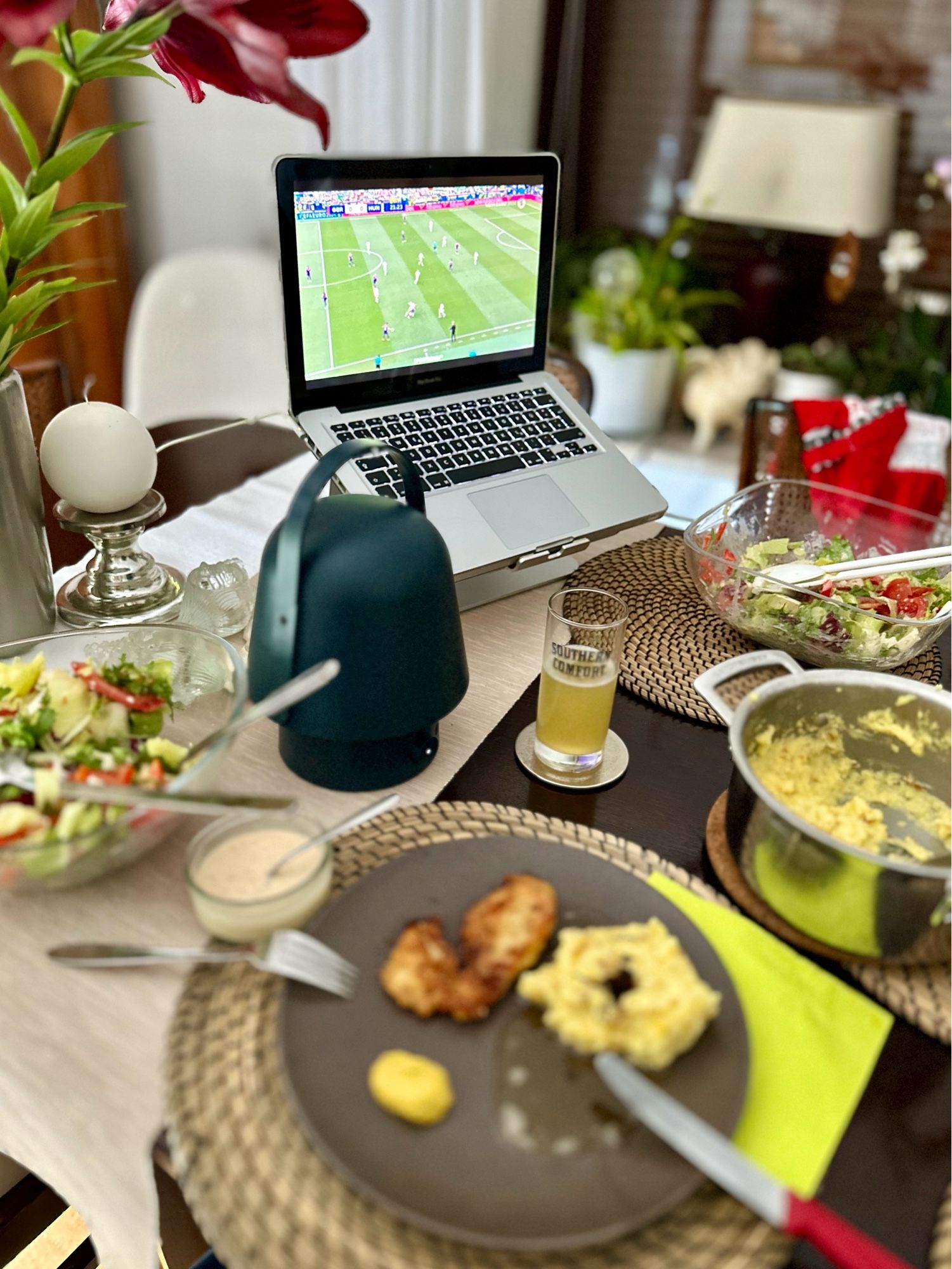 Essen auf einen Tisch; im Hintergrund ein Laptop mit einem Fußball Spiel