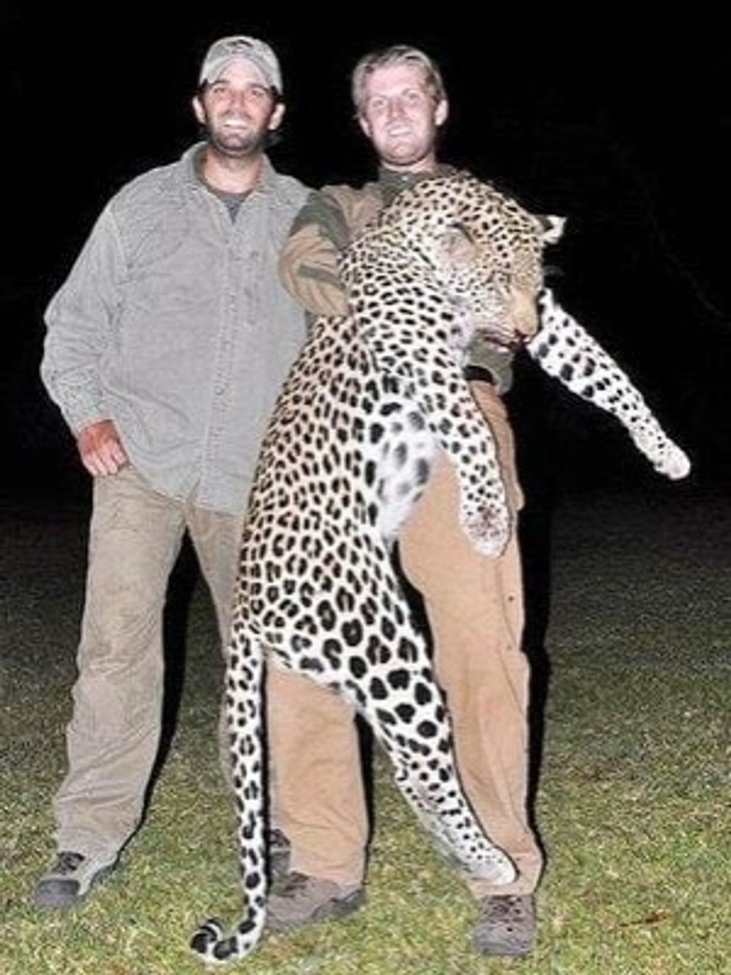 A grinning Donald Trump Jr (left) and Eric Trump (right) posing for a picture. Eric is holding the body of a dead leopard which they shot on a big game hunting trip in Africa. This photo is from 2015.