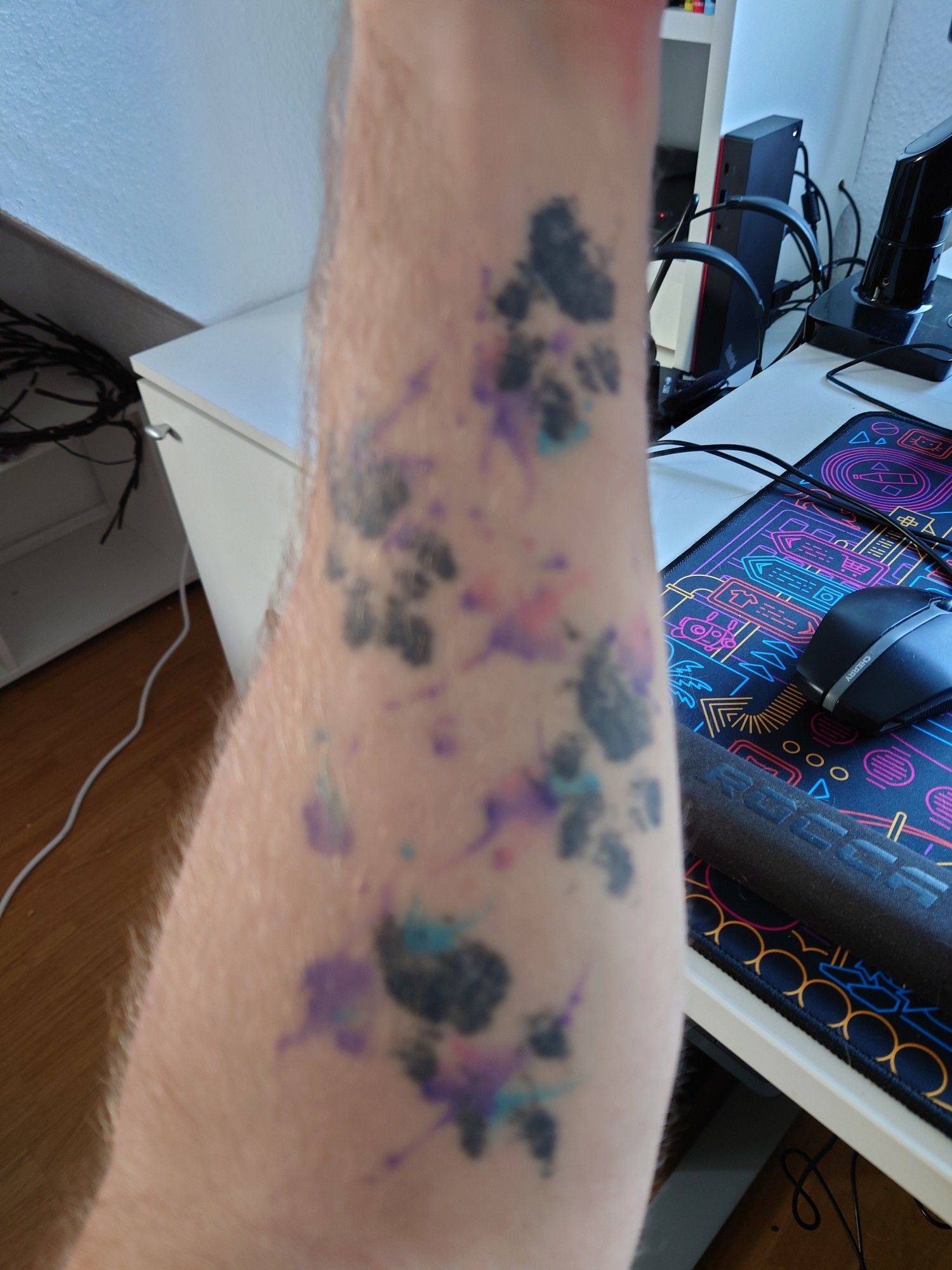 A photo of cat paw tattoos with watercolour on my forearm.