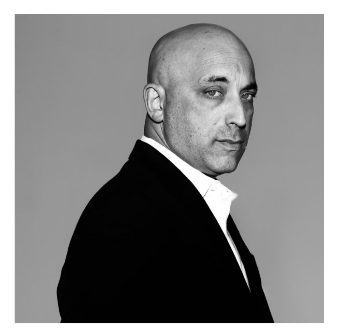 ADL head Jonathan Greenblatt looking sidelong at the camera, toughly, with bad posture.
