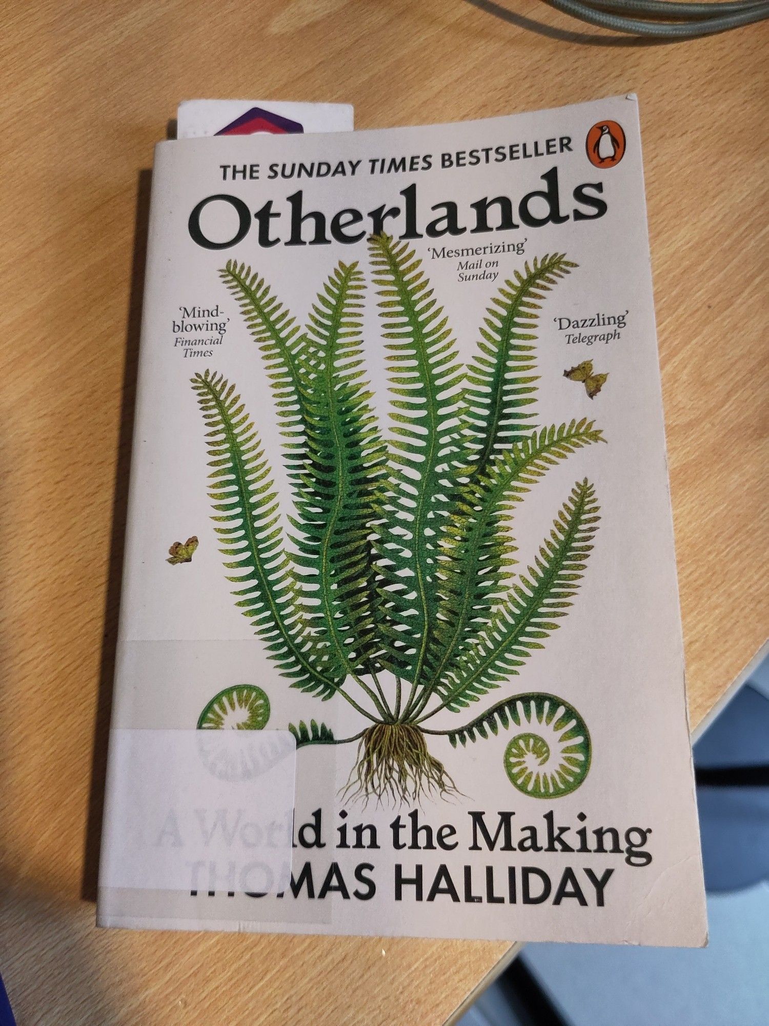 Livre "Otherlands" de Thomas Halliday avec une fougère sur la couverture.